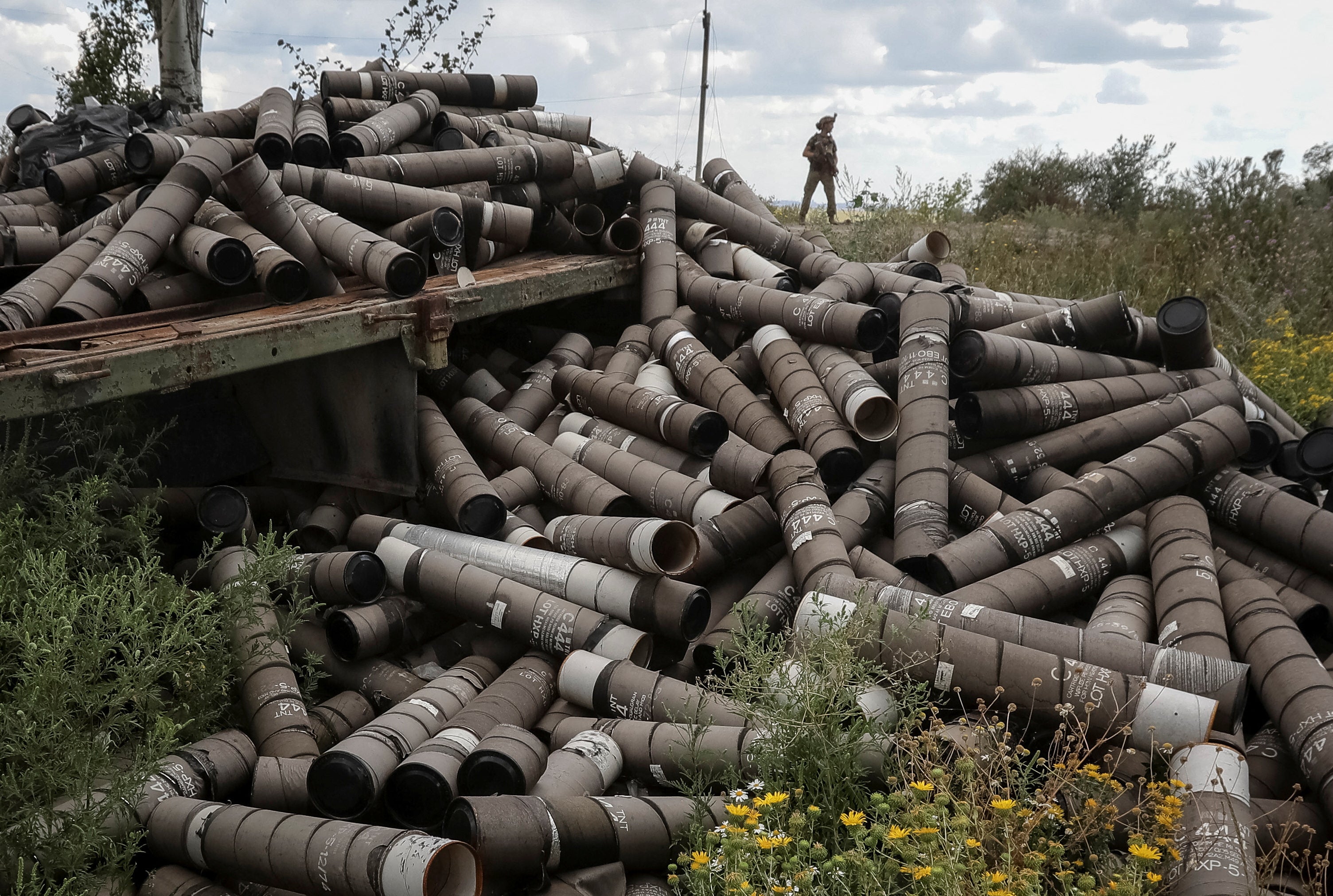 A Ukrainian serviceman of the 93rd Mechanized Brigade stands near used shell cartridges as he patrols an area