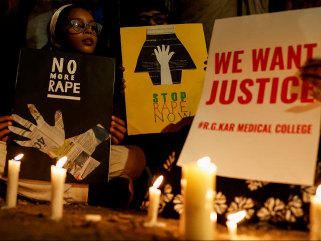 <p>People hold posters during a vigil condemning the rape and murder of a trainee medic at a government hospital in Kolkata, on a street in Mumbai, India, on 14 August 2024</p>