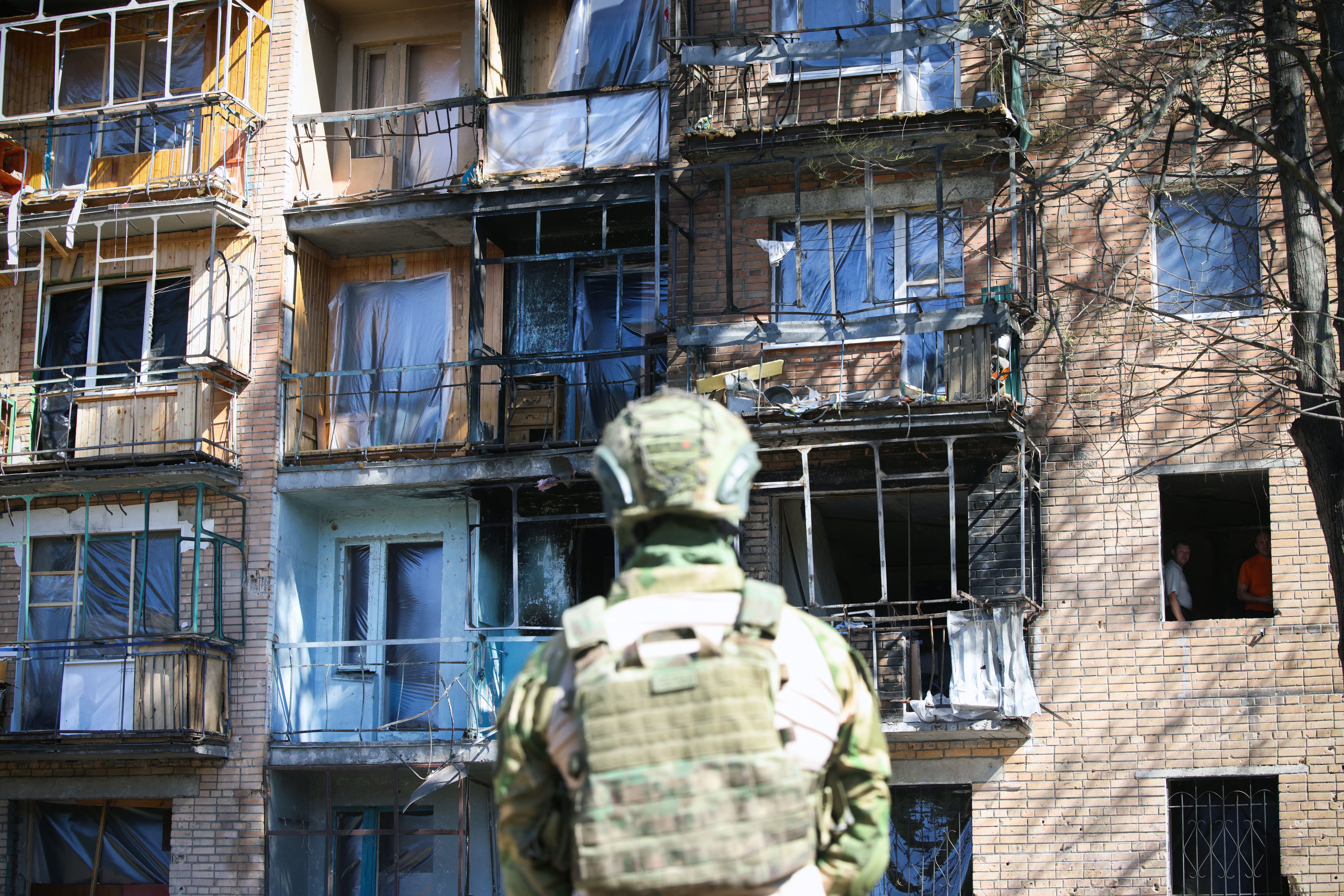 A local volunteer inspects a building in Kursk that was reportedly damaged by Ukrainian airstrikes.