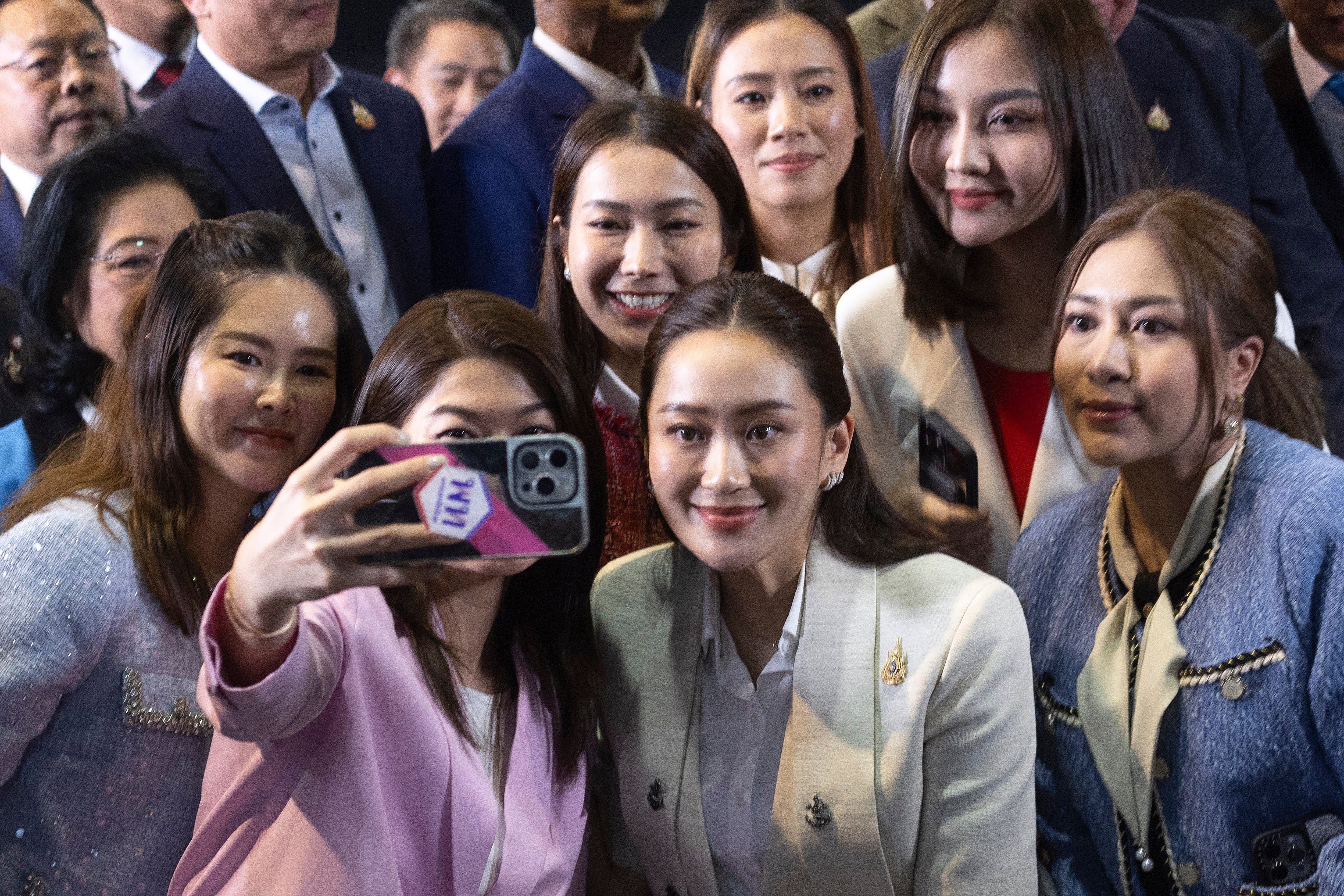 A recém-eleita Paetongtarn Shinawatra posa para uma selfie com membros de seu partido Pheu Thai