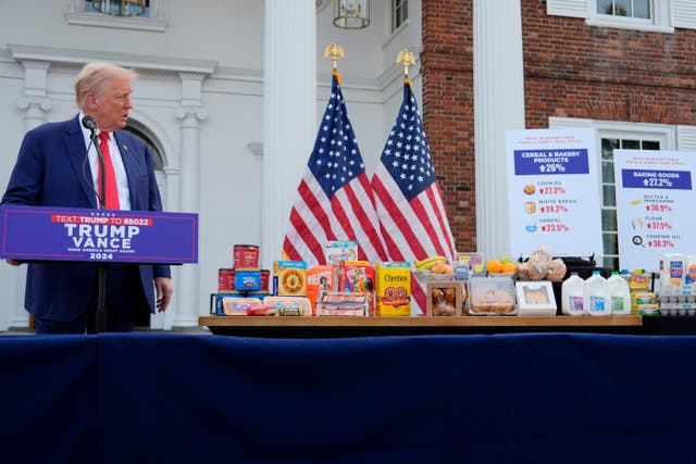 <p>Donald Trump admires a box of Cheerios during a press conference in Bedminster, New Jersey</p>