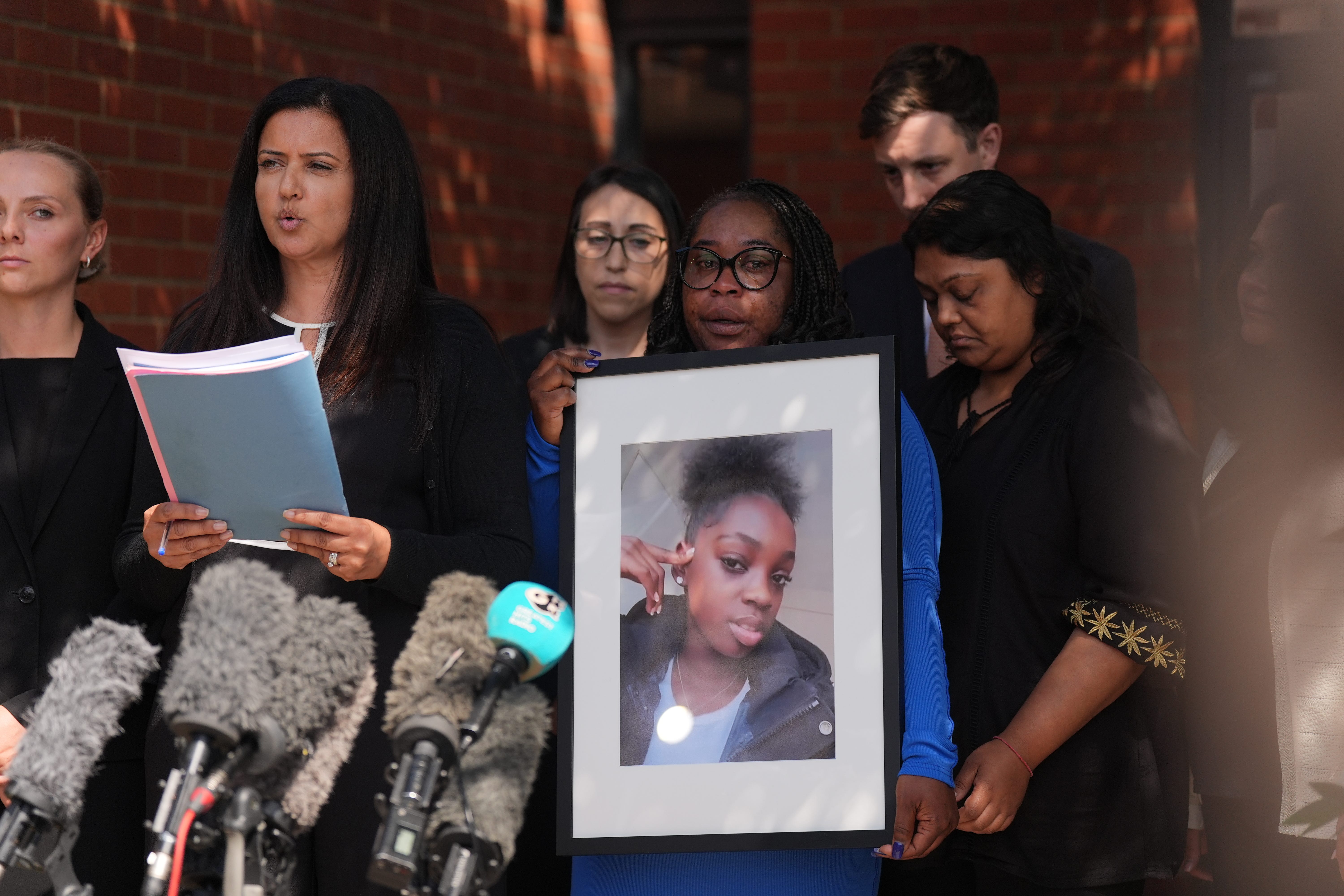 <p>Hannah’s mother, Abimbola Duyile, holds a picture of her daughter outside East London Coroner’s Court (Yui Mok/PA)</p>