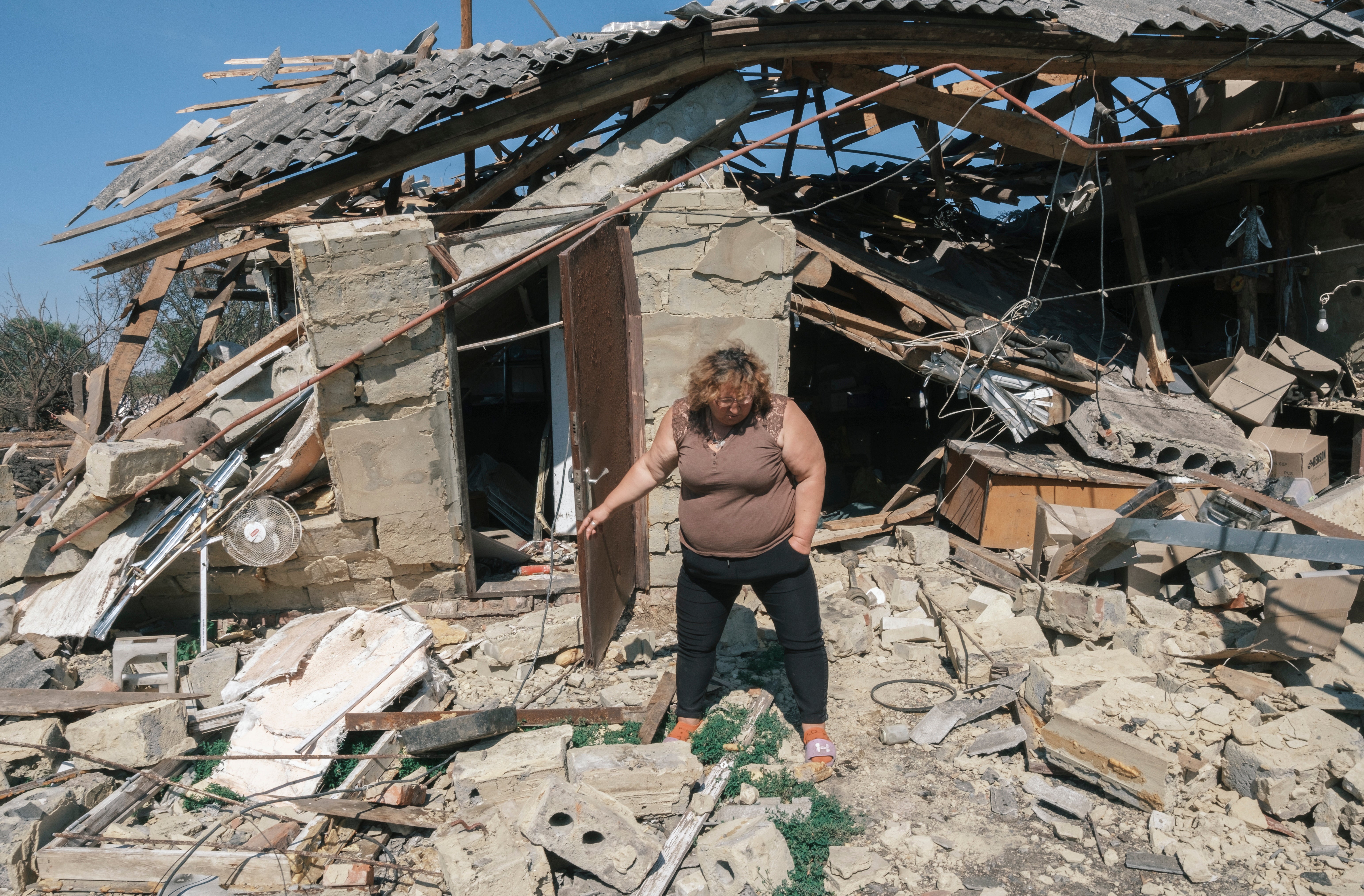 Local Ukrainian woman Natalia inspects the destroyed home of an aquaintance in a village not far from the Ukraine - Russian border in the Kursk direction of the Sumy region, Ukraine