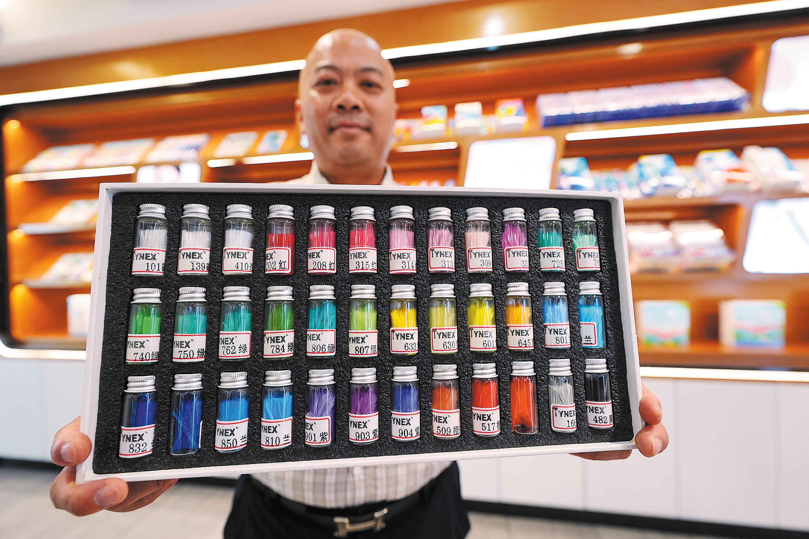 An employee showcases different kinds of toothbrush fibres in Hangji town of Yangzhou, Jiangsu province, in June