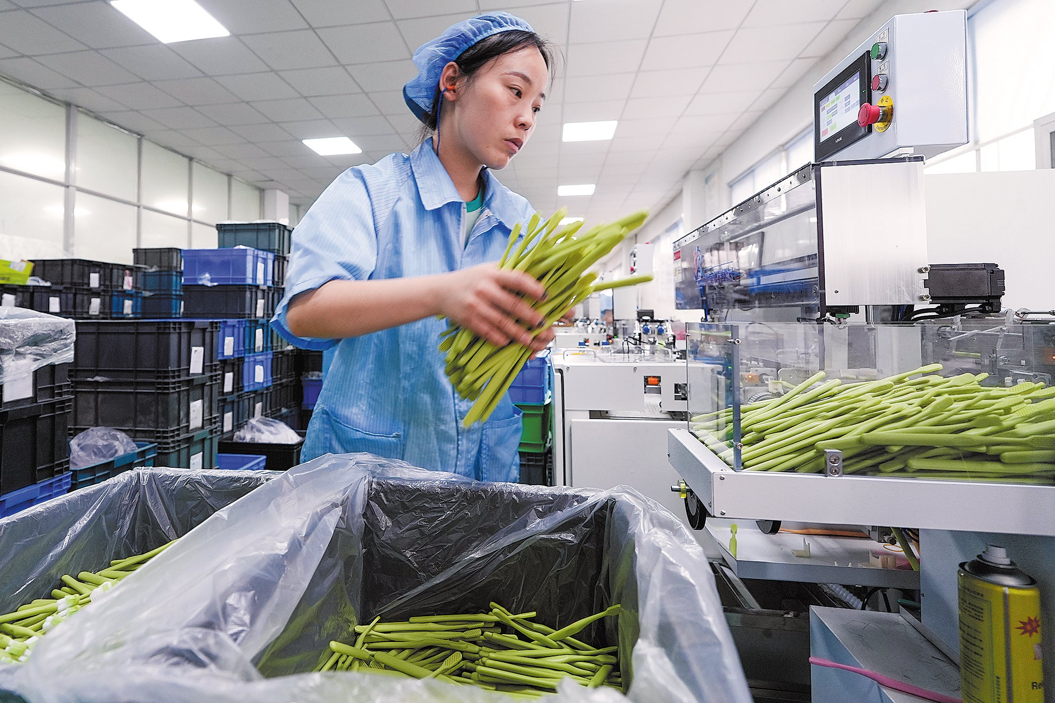 A worker operates a production line of toothbrushes in Hangji