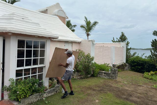 <p>A man boards up his house in Warwick, Bermuda ahead of Hurricane Ernesto, which has strengthened into a Category 2 storm</p>