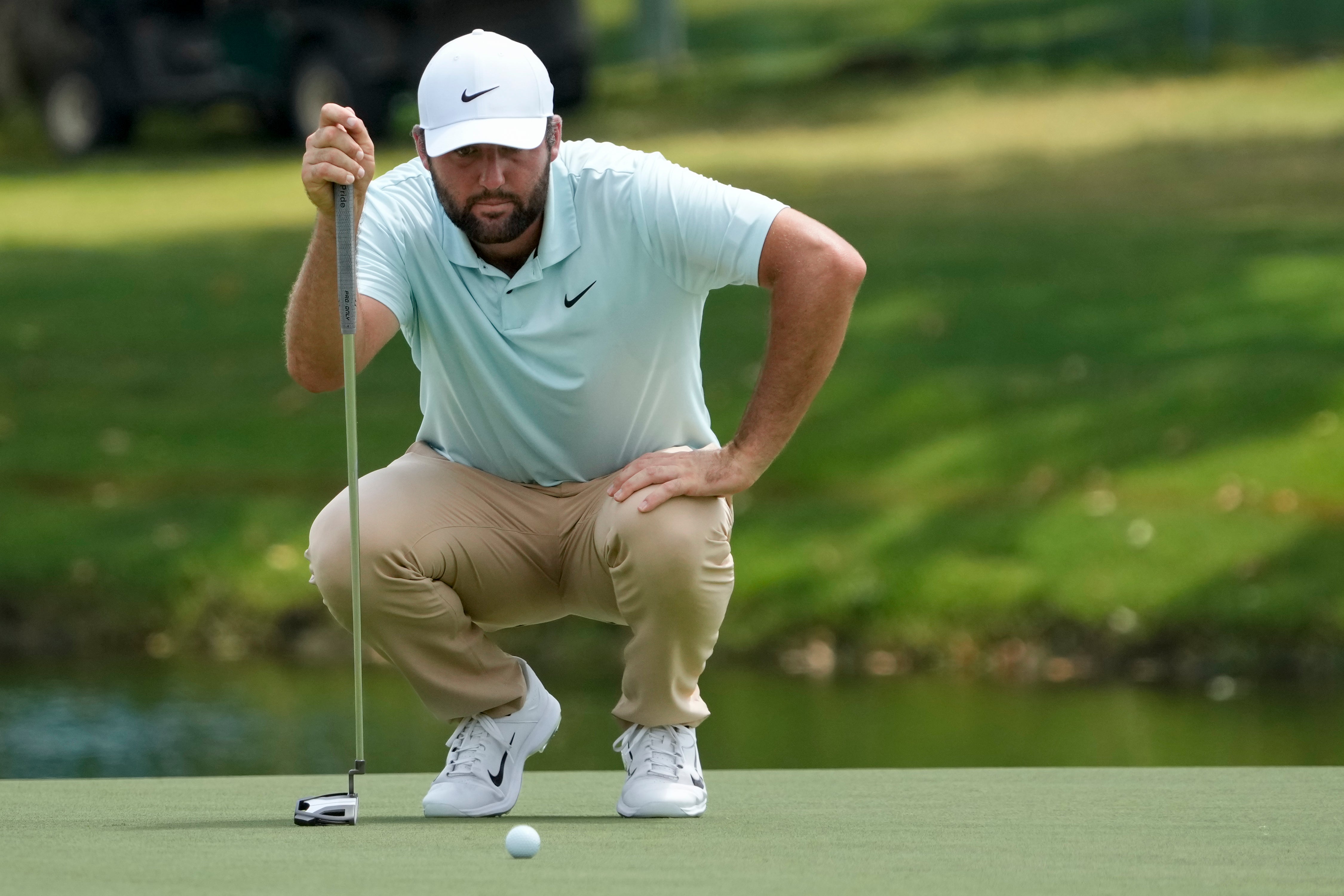 Scottie Scheffler lines up his putt on the 18th green (Mark Humphrey/AP)