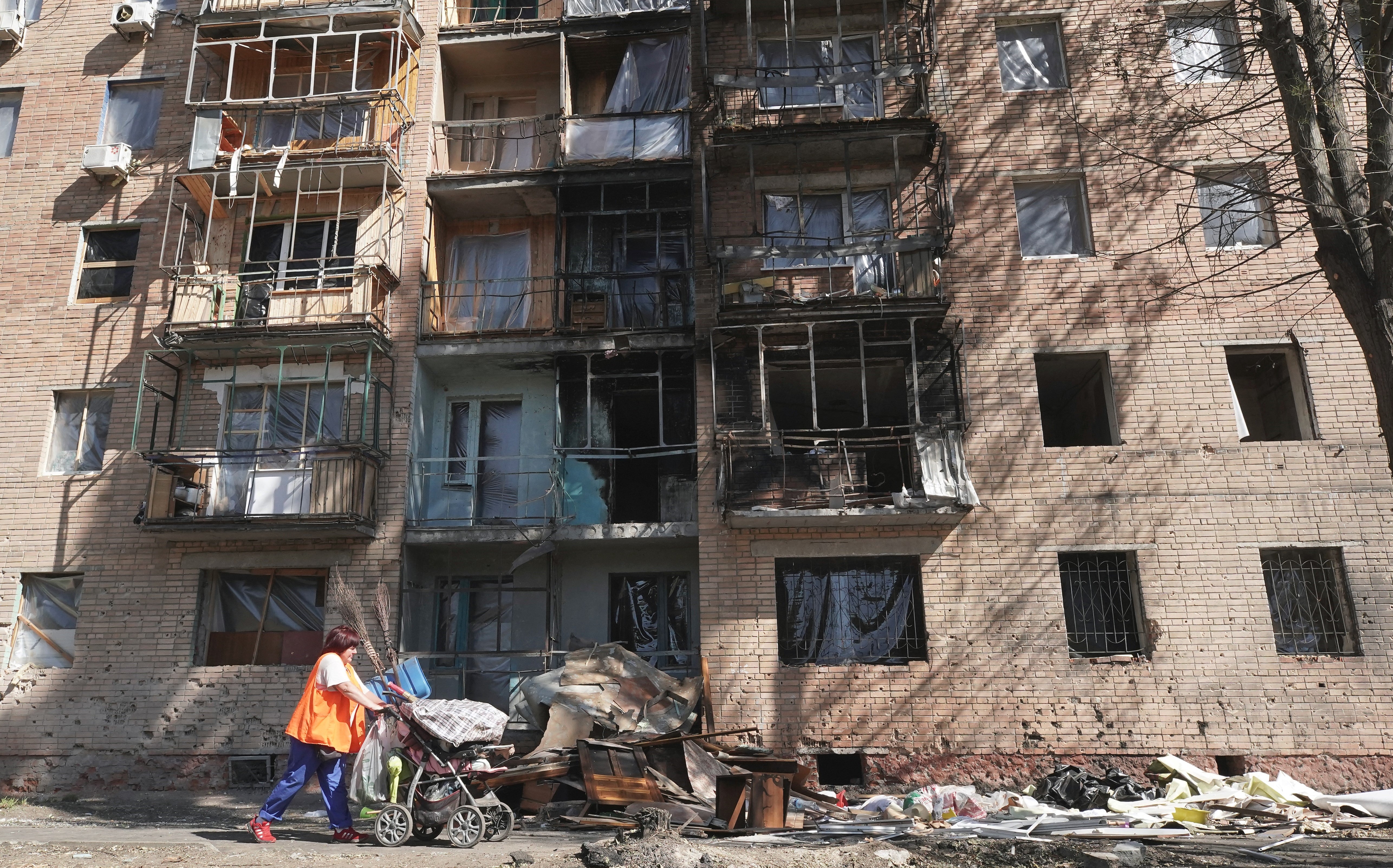 A woman walks past a building damaged by Ukrainian strikes in Kursk on August 16, 2024 following Ukraine’s offensive into Russia