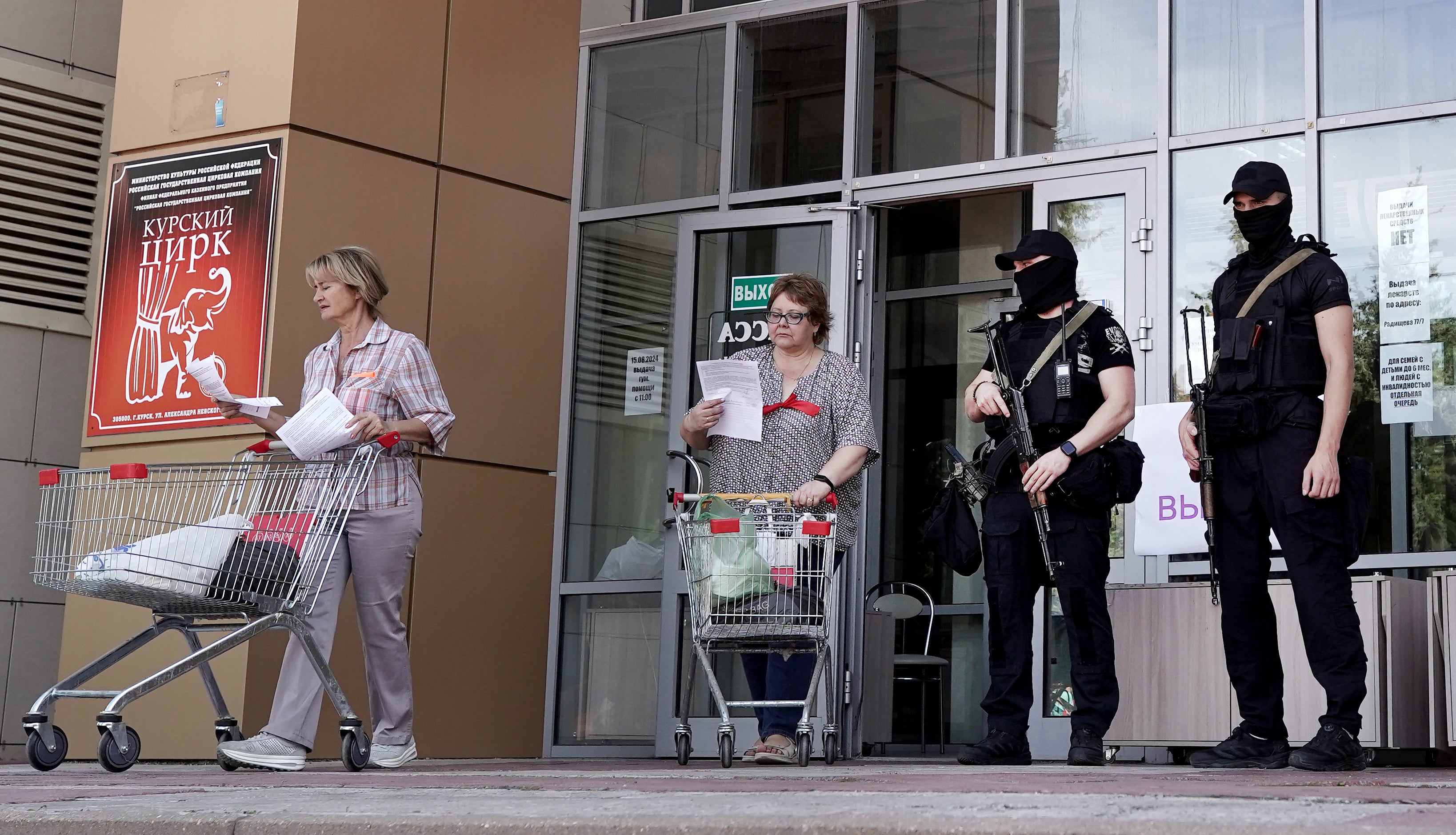 Security guards stand at the entrance of a center for displaced people and humanitarian aid distribution in Kursk on August 16, 2024, following Ukraine’s offensive into Kursk