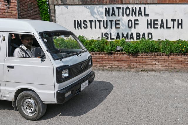 <p>A man riding a vehicle moves past the National Institute of Health (NIH), a Pakistani research institute mainly responsible for biomedical and health-related research, in Islamabad on 16 August 2024</p>