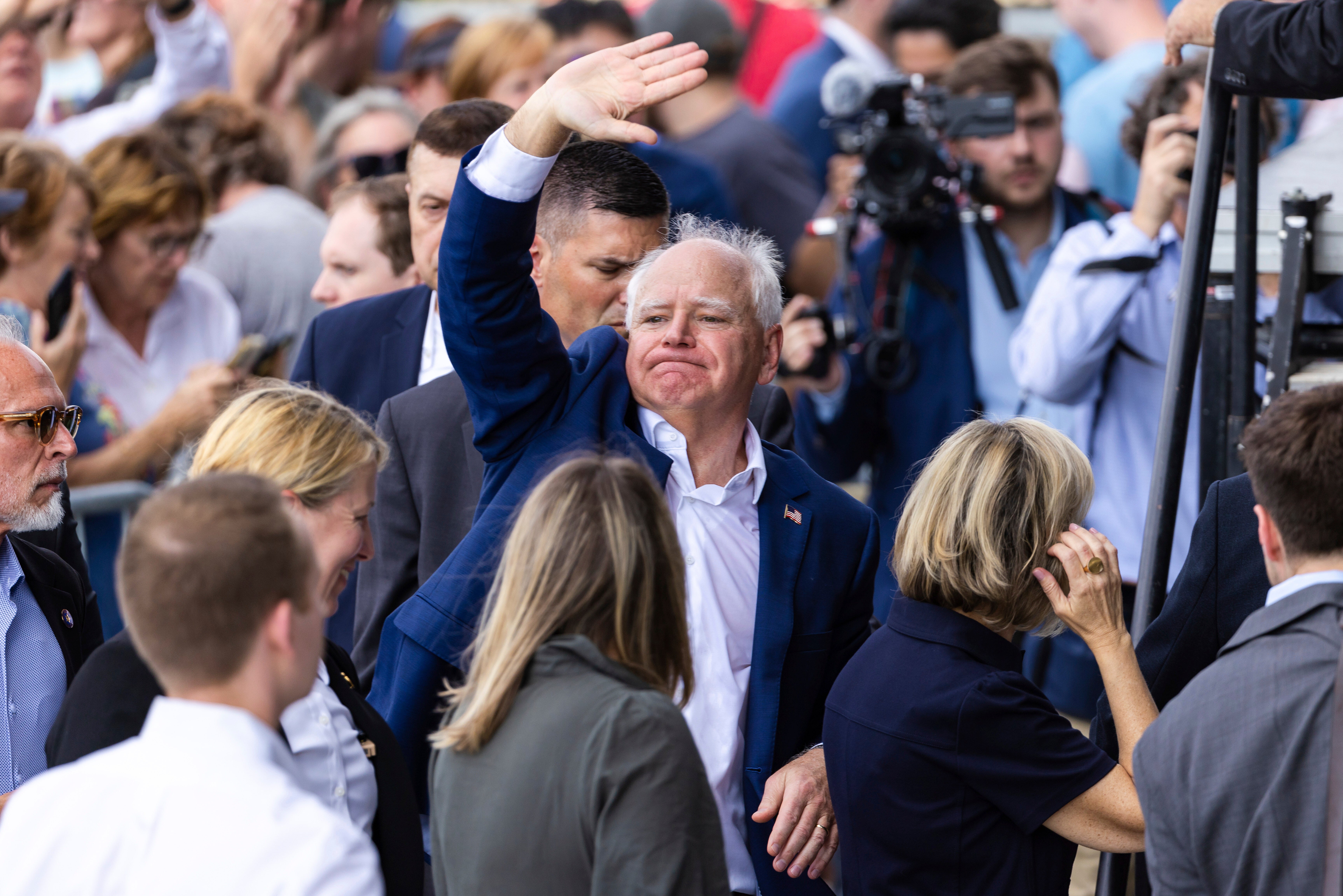 Democratic vice presidential candidate Tim Walz waves to the crowd outside after a campaign rally