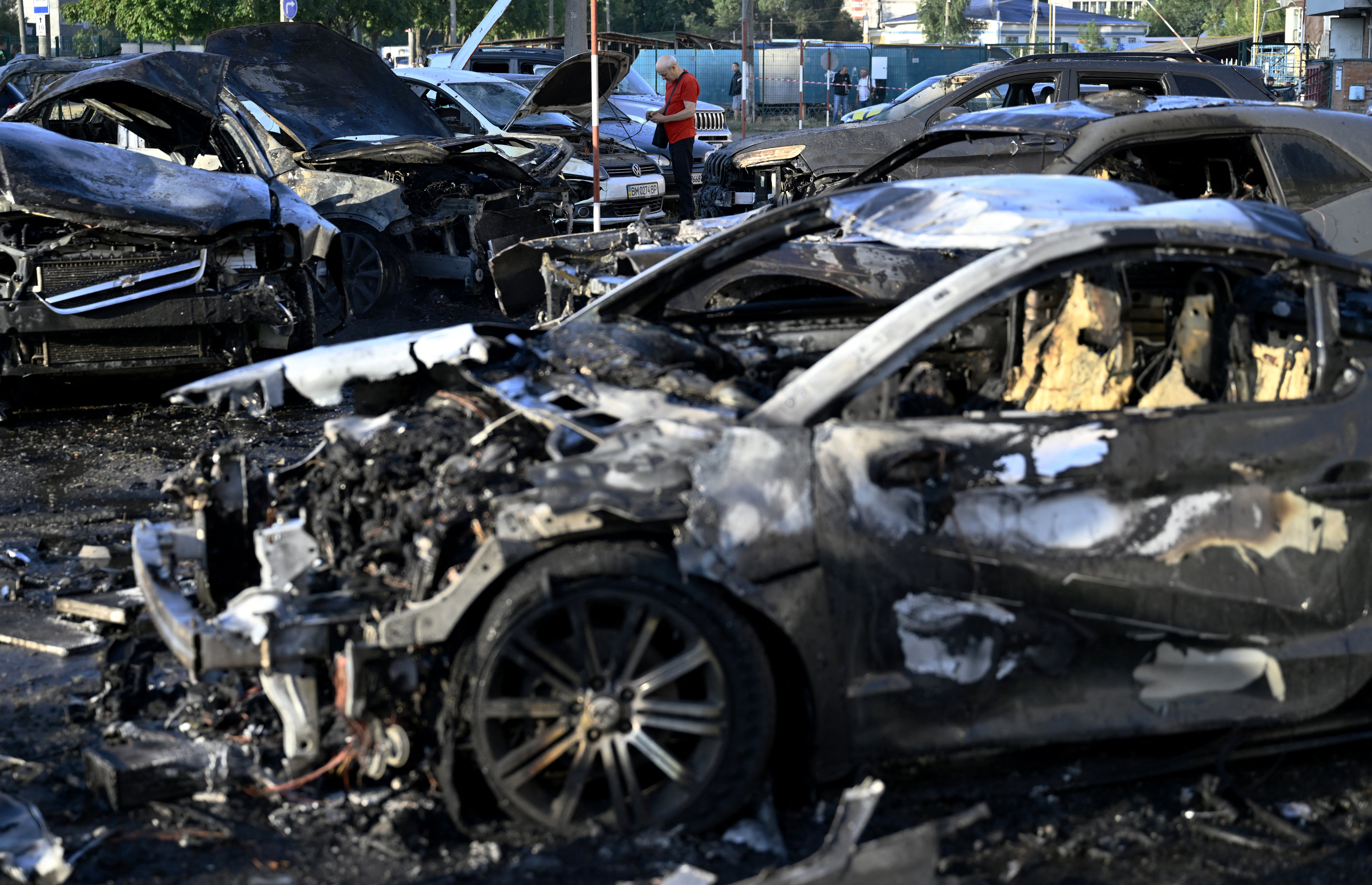 A man inspects a damaged car at the site of a Russian strike in the city of Sumy on August 17, 2024