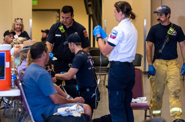 <p>Members of the Colorado Springs Fire Department and AMR paramedics treat people for heat-related illness at the Pikes Peak Regional Airshow</p>