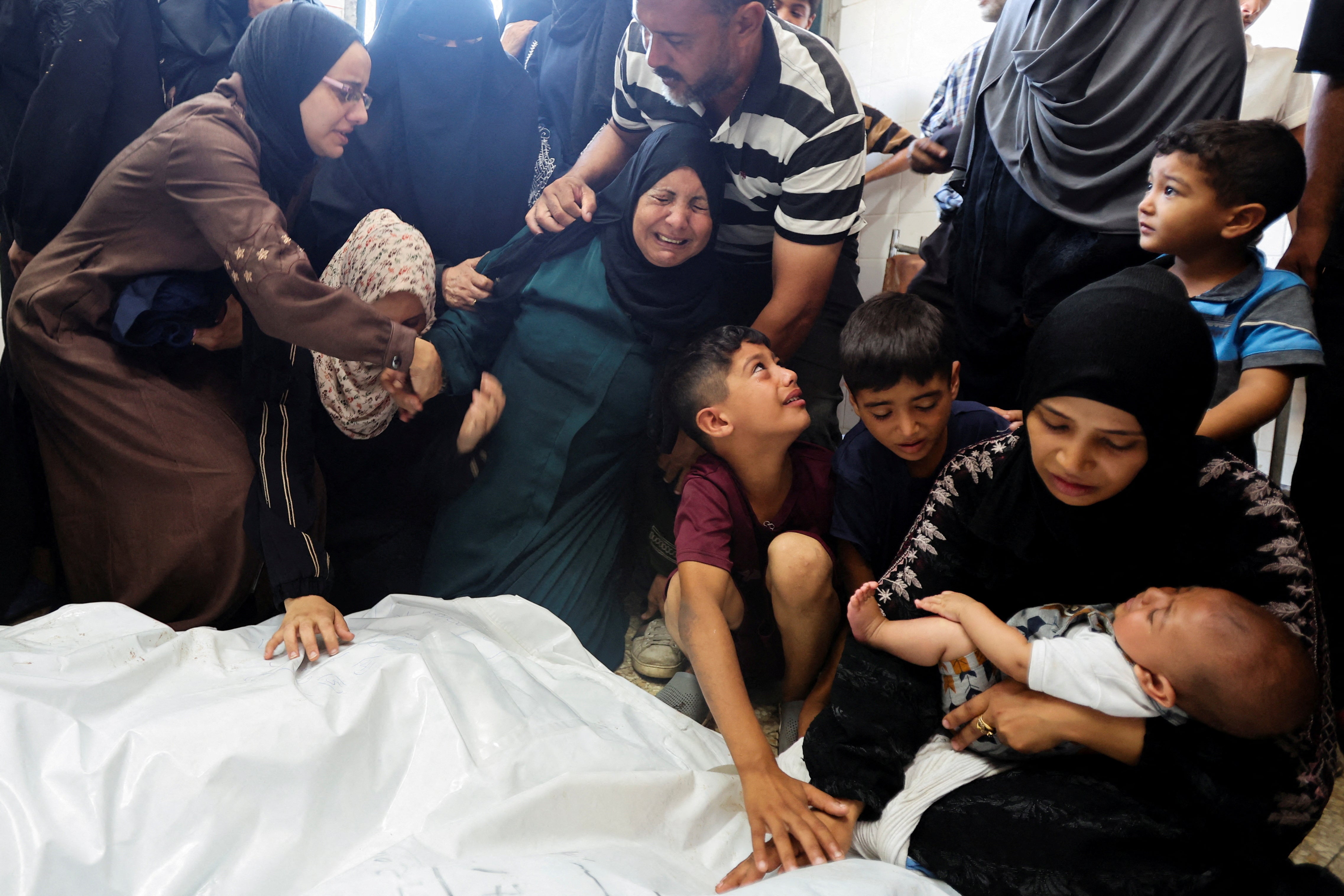 Mourners react next to the bodies of Palestinians killed in Israeli strikes, amid the Israel-Hamas conflict, at Al-Aqsa Martyrs Hospital in Deir Al-Balah in the central Gaza Strip, August 18, 2024.