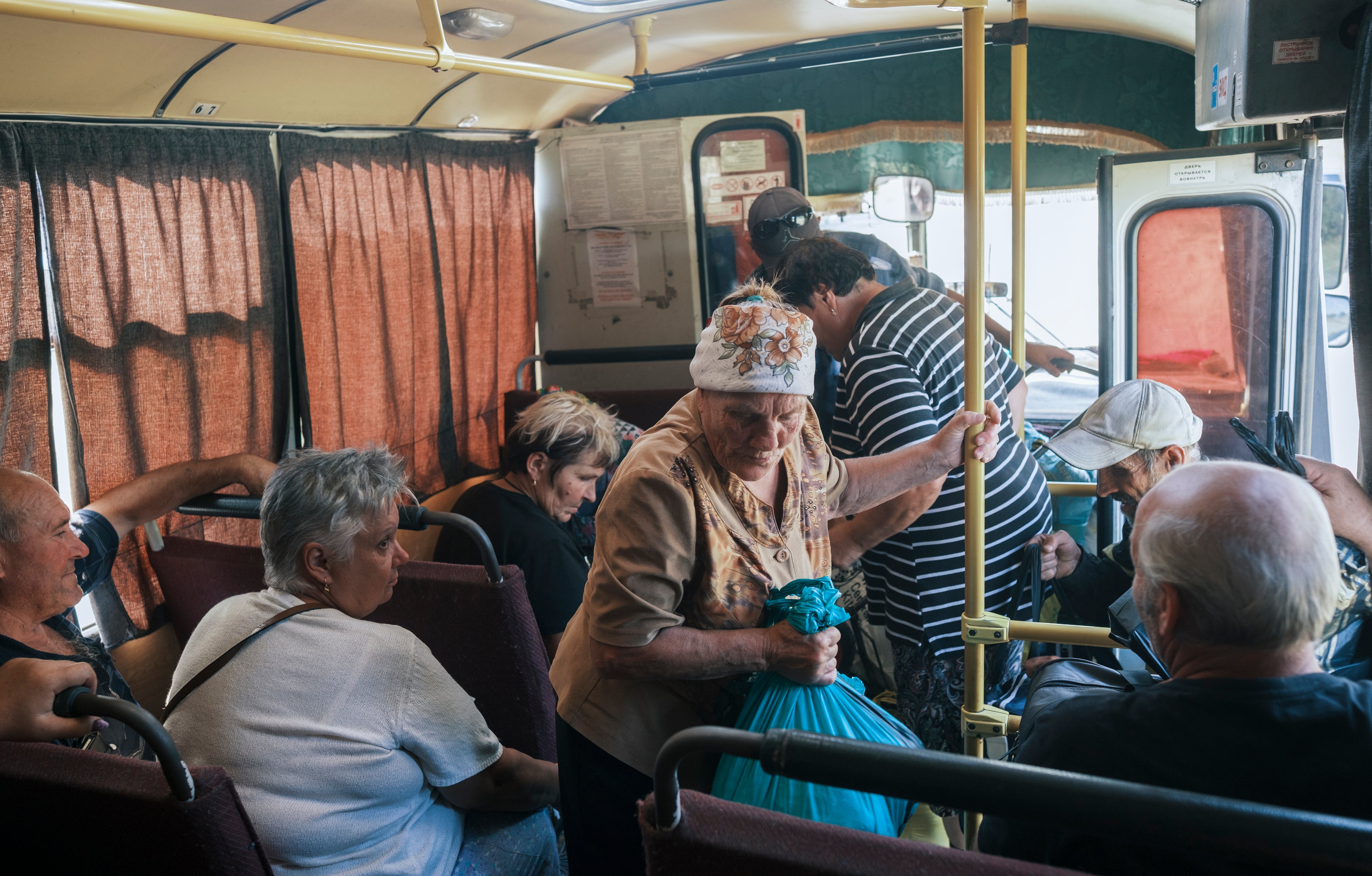 Locals bord a bus to Sumy in the village of Yunakivka, 9 kilometers from the border with Russia in the Sumy region, Ukraine