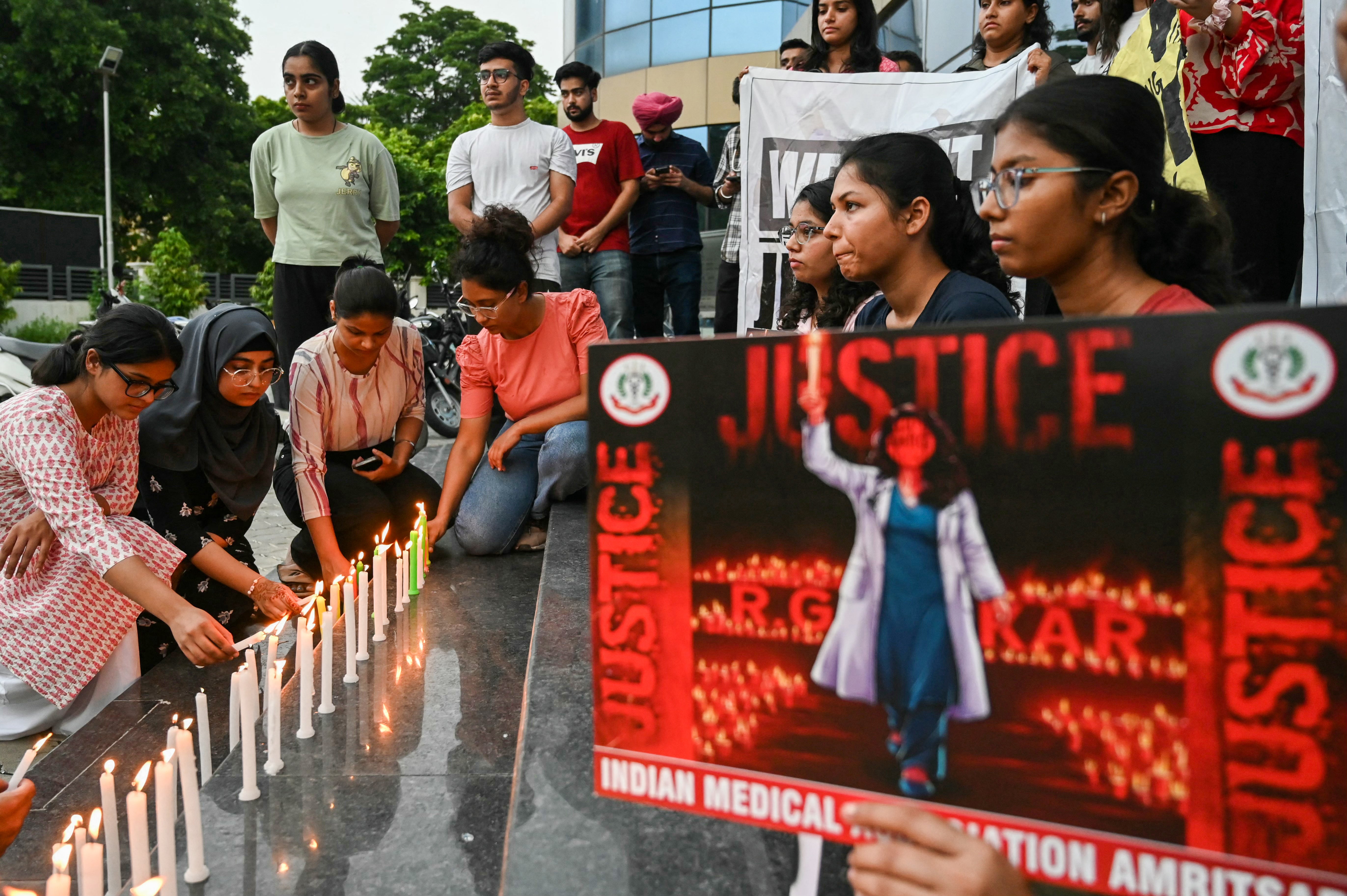 <p>Medical professionals light candles as they  pay tribute to a young doctor raped and murdered in Kolkata</p>