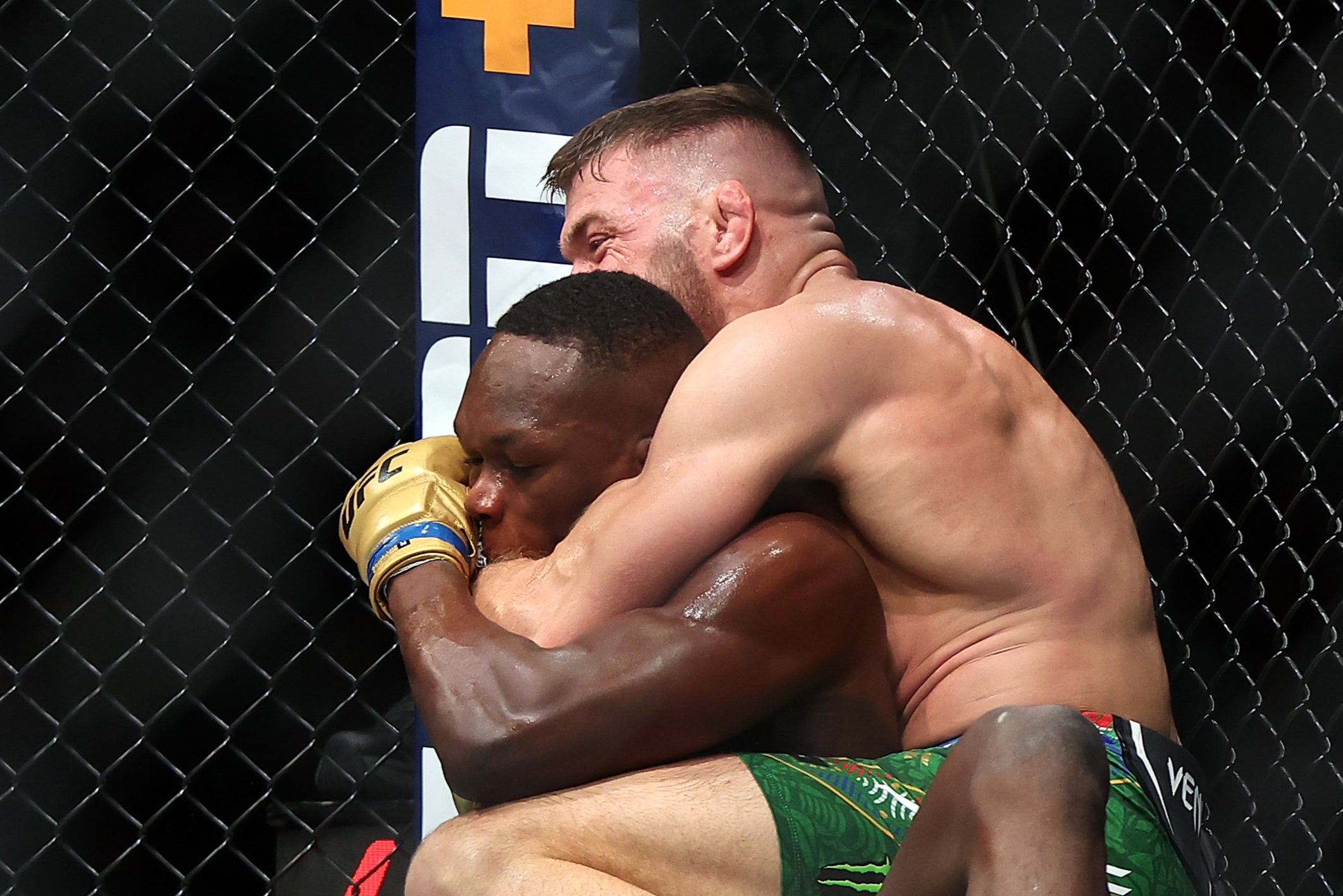 Israel Adesanya (left) tries to prevent Dricus Du Plessis from making a chokehold