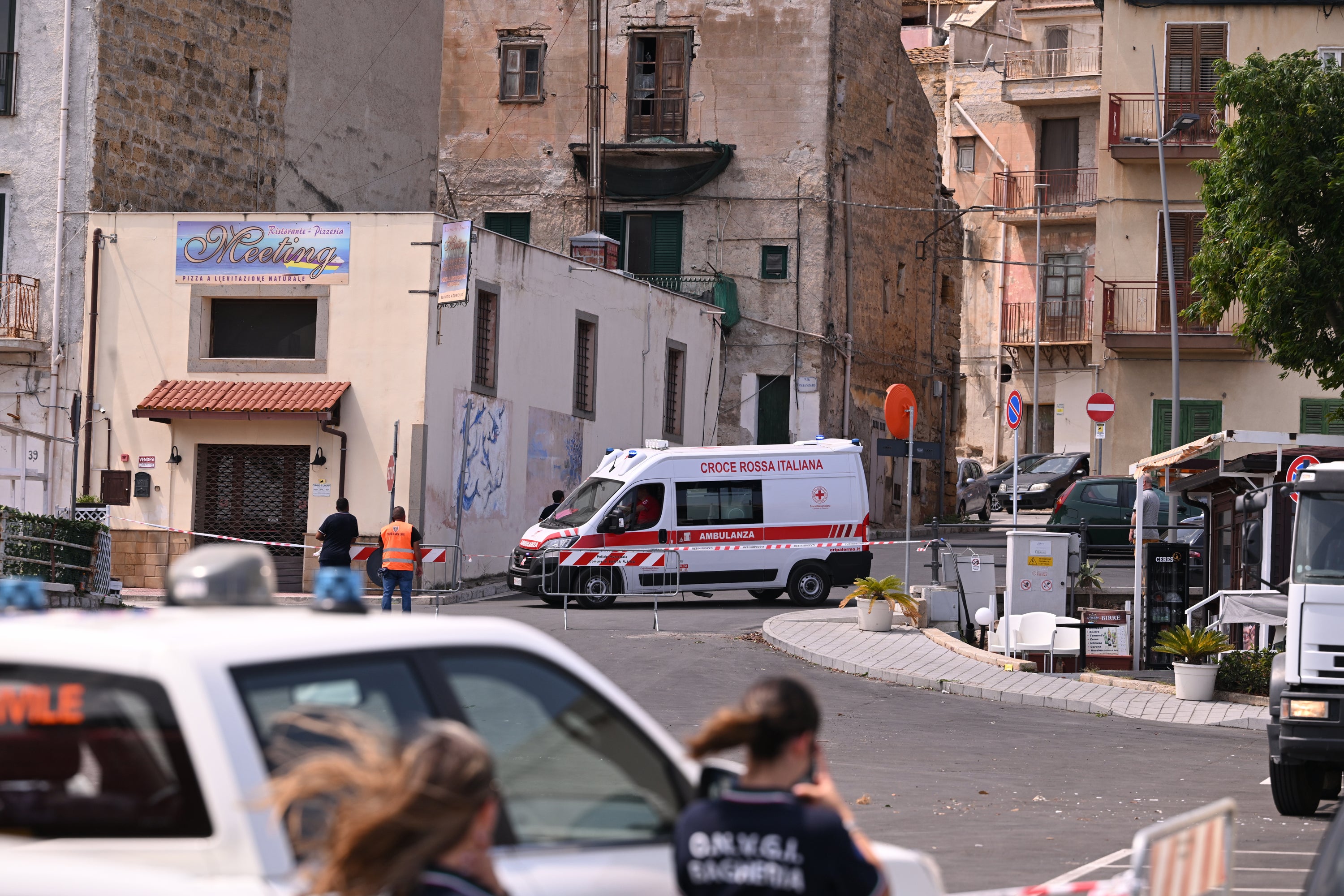 An ambulance is parked near the harbour in Porticello where a search continues for missing passengers after a yacht capsized