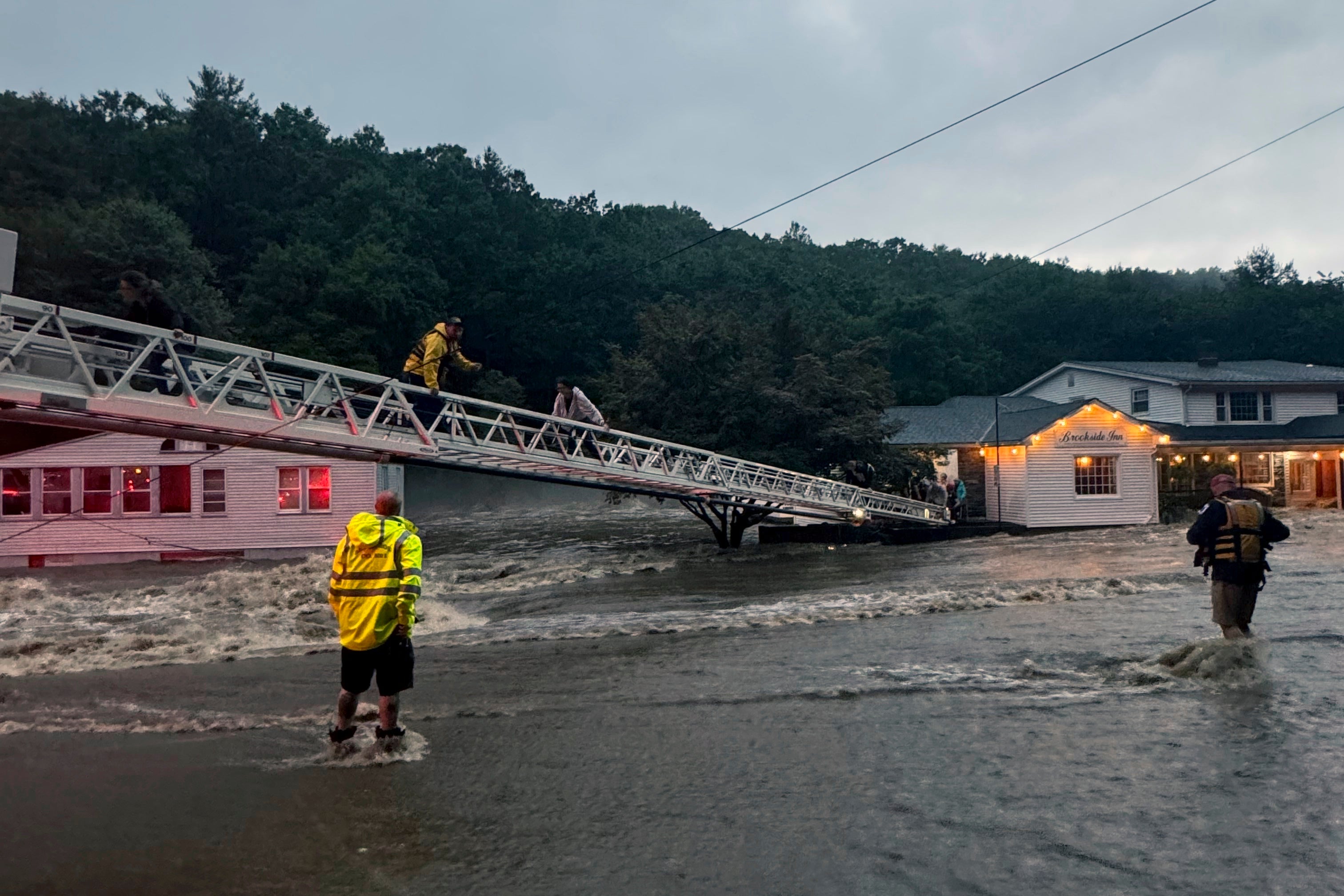 This photo provided by Beacon Hose Co. No. 1, a fire station in Beacon Falls, Connecticut, shows members of Beacon Hose Co. rescuing people from the Brookside Inn in Oxford, Conn., Sunday, Aug. 18, 2024.