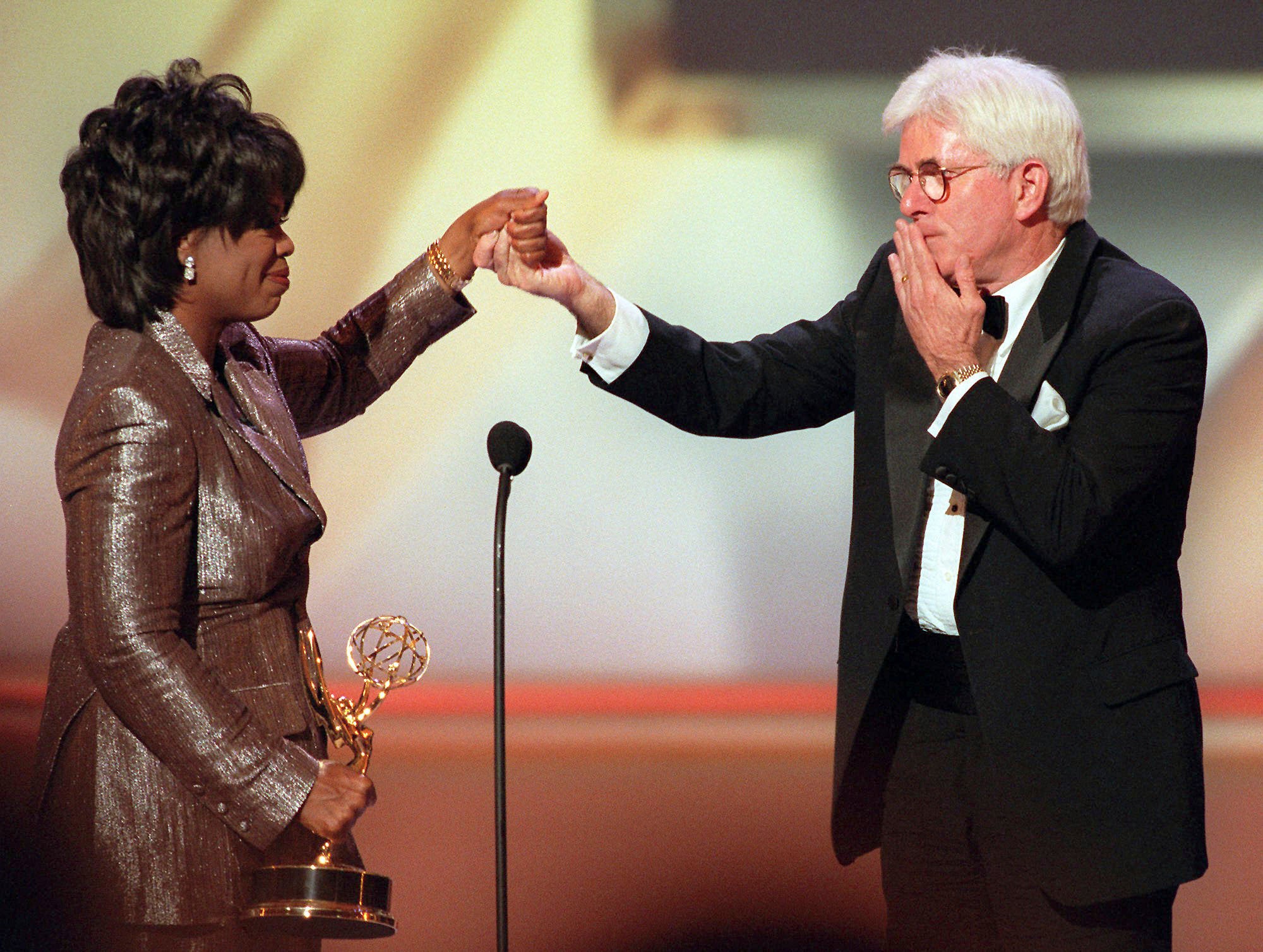 Donahue blows a kiss to Oprah Winfrey as she presents him with a Lifetime Achievement Award at the 23rd Annual Daytime Emmy Awards in New York in 1996