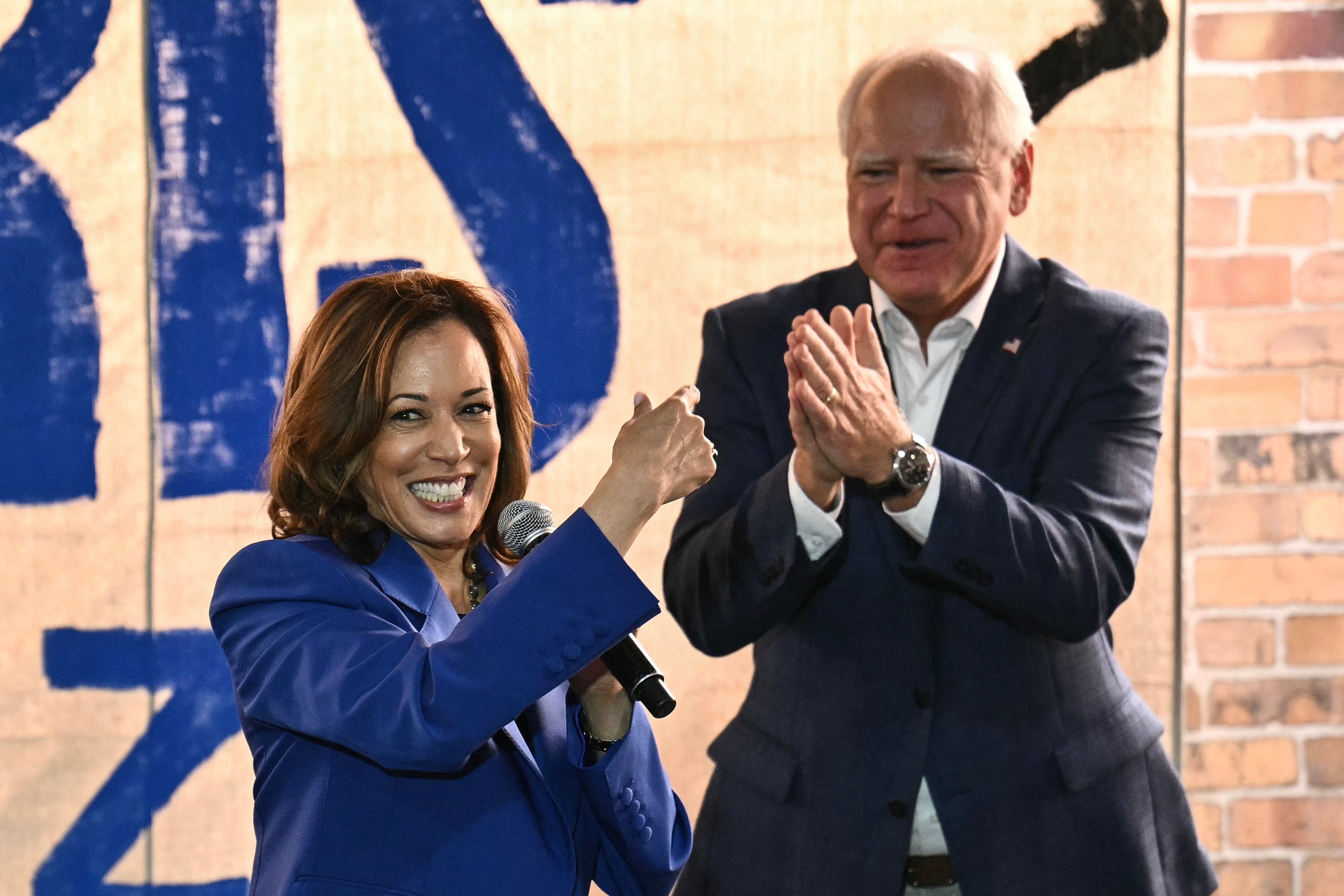 Vice President and Democratic presidential candidate Kamala Harris (L) speaks as her running mate Minnesota Governor Tim Walz looks on during a campaign bus tour in Rochester, Pennsylvania, on August 18. Both are strong supporters of abortion rights