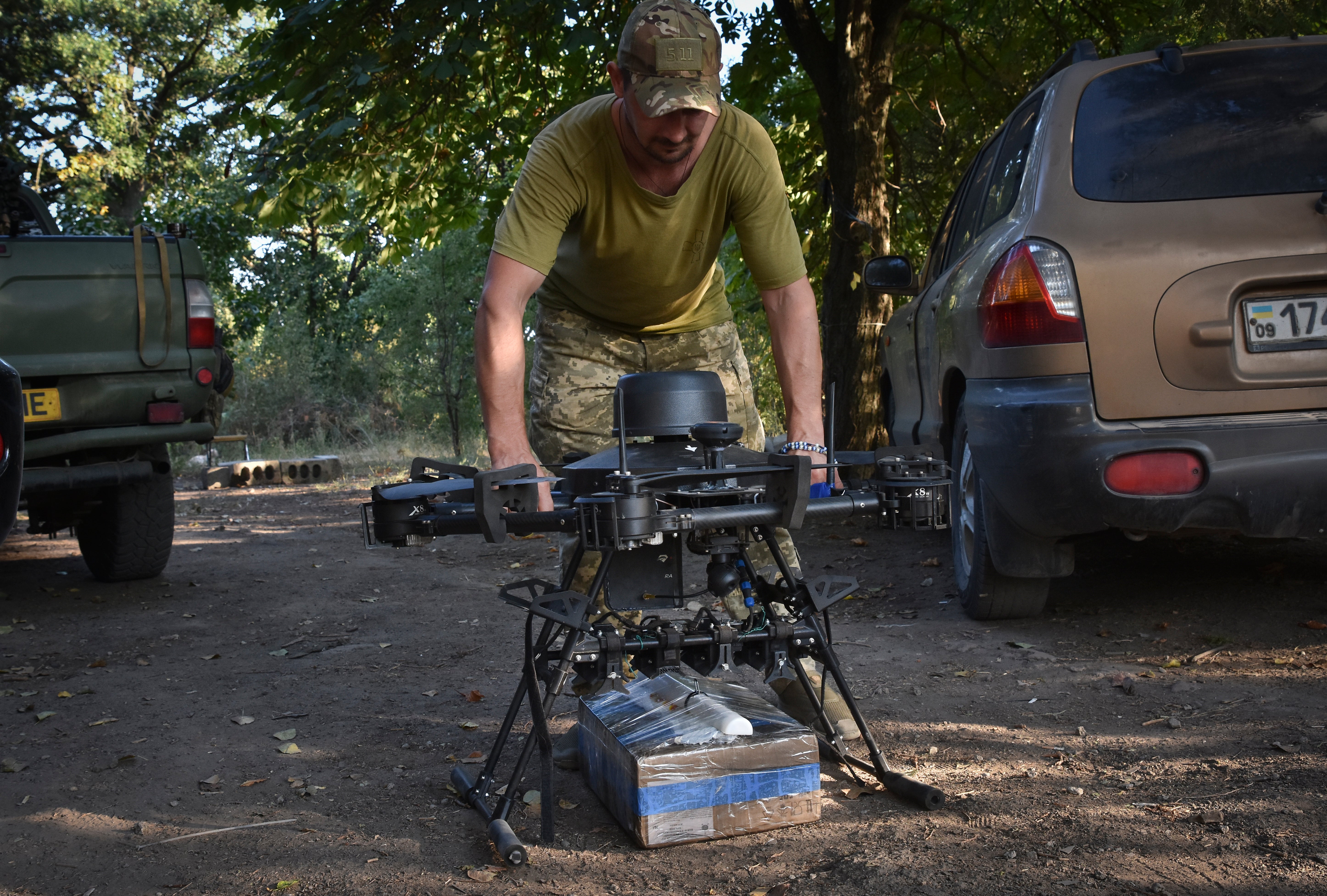 A soldier of Ukraine's 141st separate infantry brigade loads a drone with a parcel for soldiers on a mission at the frontline in Zaporizhzhia