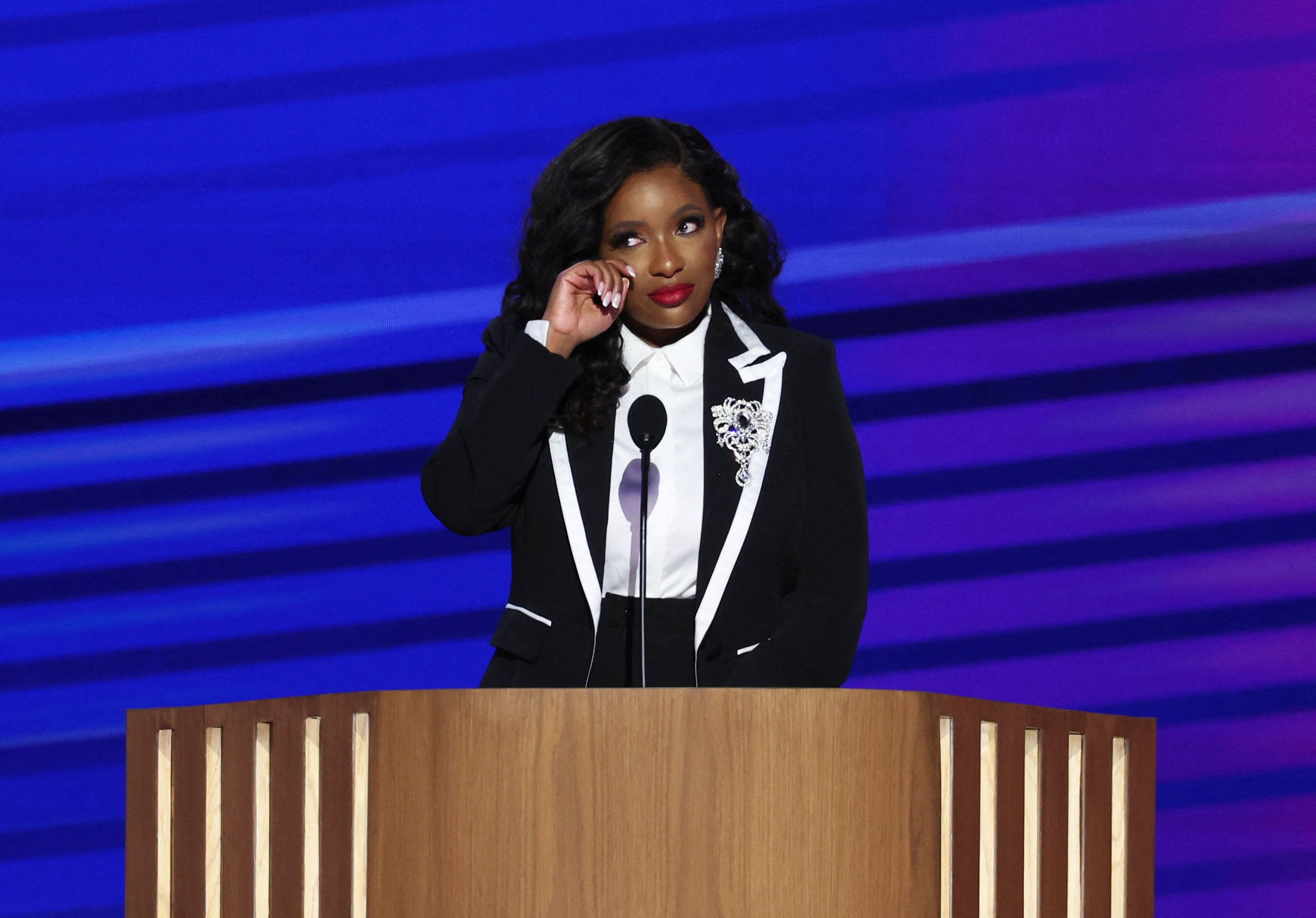 Jasmine Crockett wipes away a tear while giving a speech at the DNC