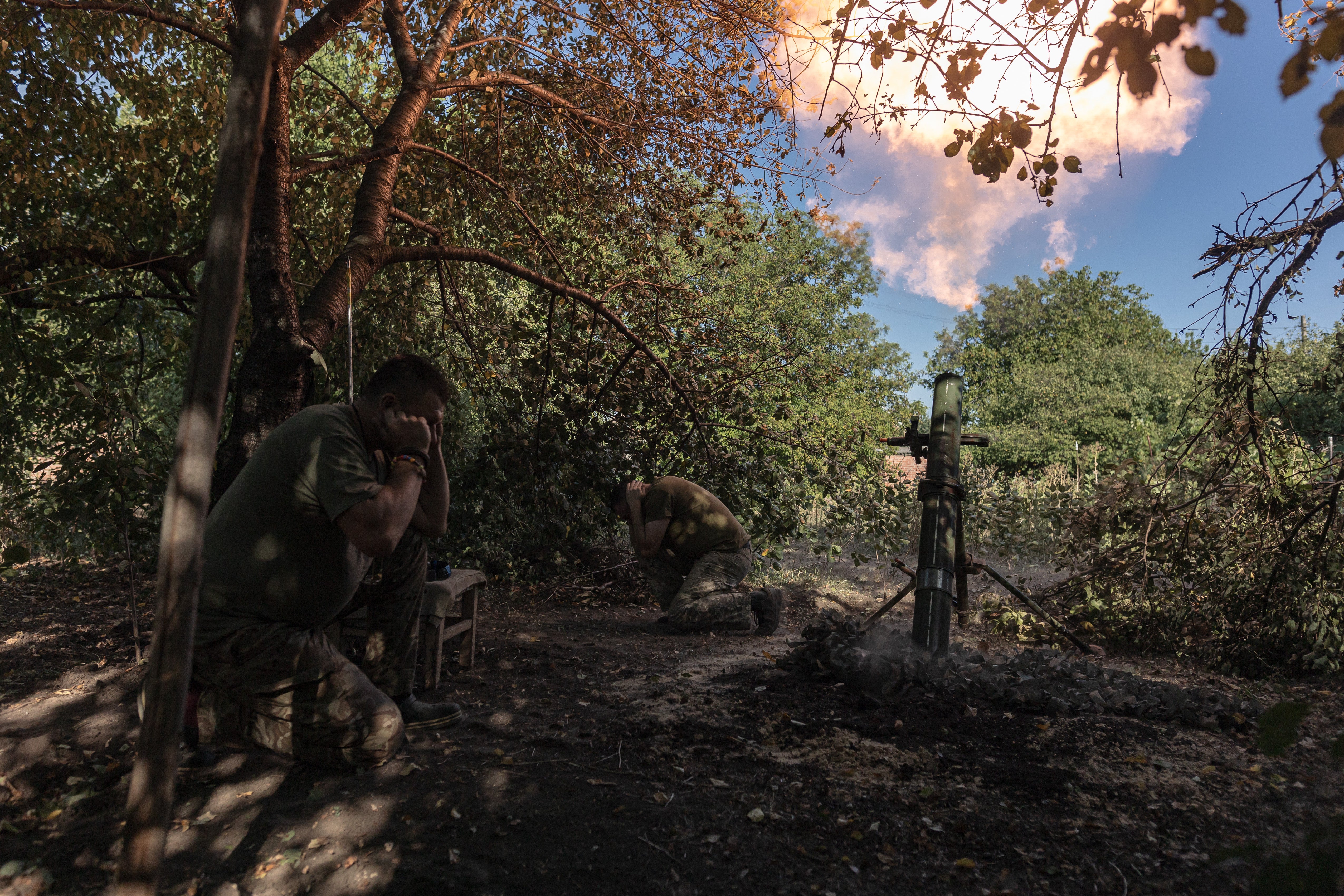 Ukrainian soldiers fire a mortar