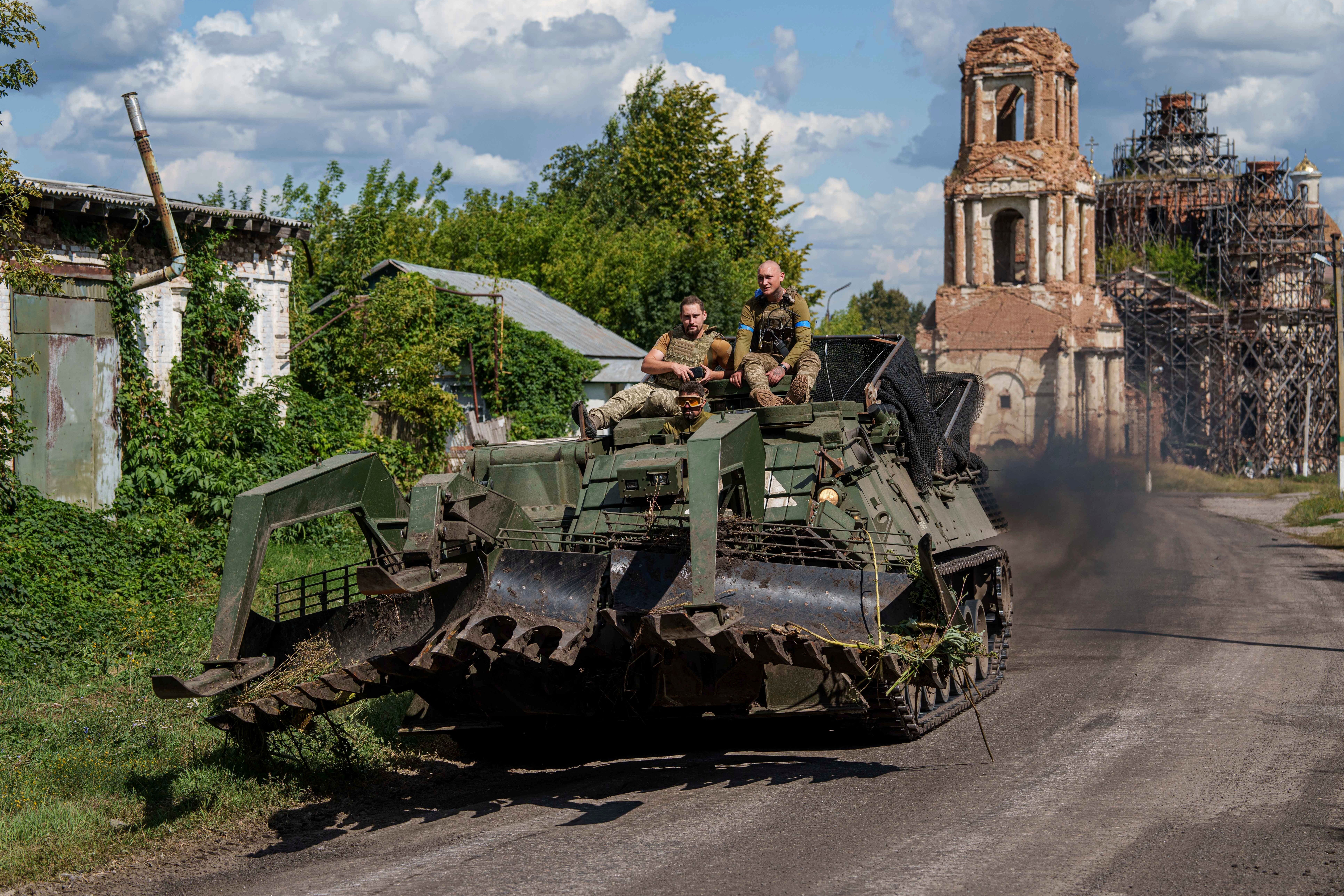 Ukrainian servicemen ride atop an armoured vehicle at the Russian-Ukrainian border in Ukraine’s Sumy region