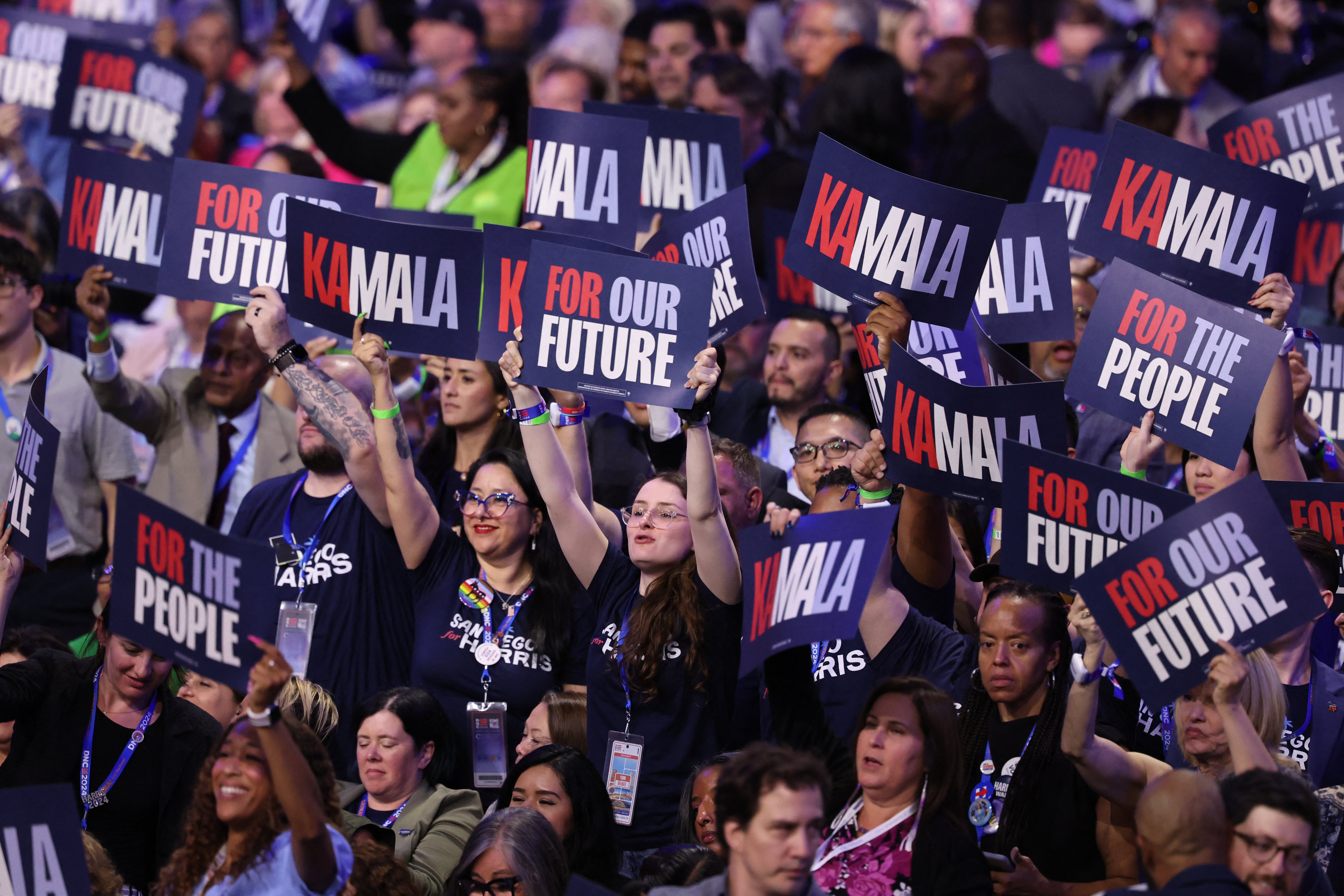 On the second day of the Democratic National Convention, participants hold signs in support of Kamala Harris.