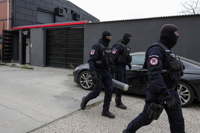 <p>Police officers outside Tate residence </p>