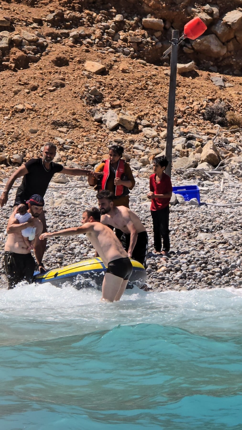 The baby being rescued from the beach on Tilos