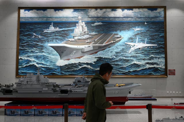 <p>A man walks past a model and painting of China’s Liaoning aircraft carrier at the Military Museum in Beijing </p>