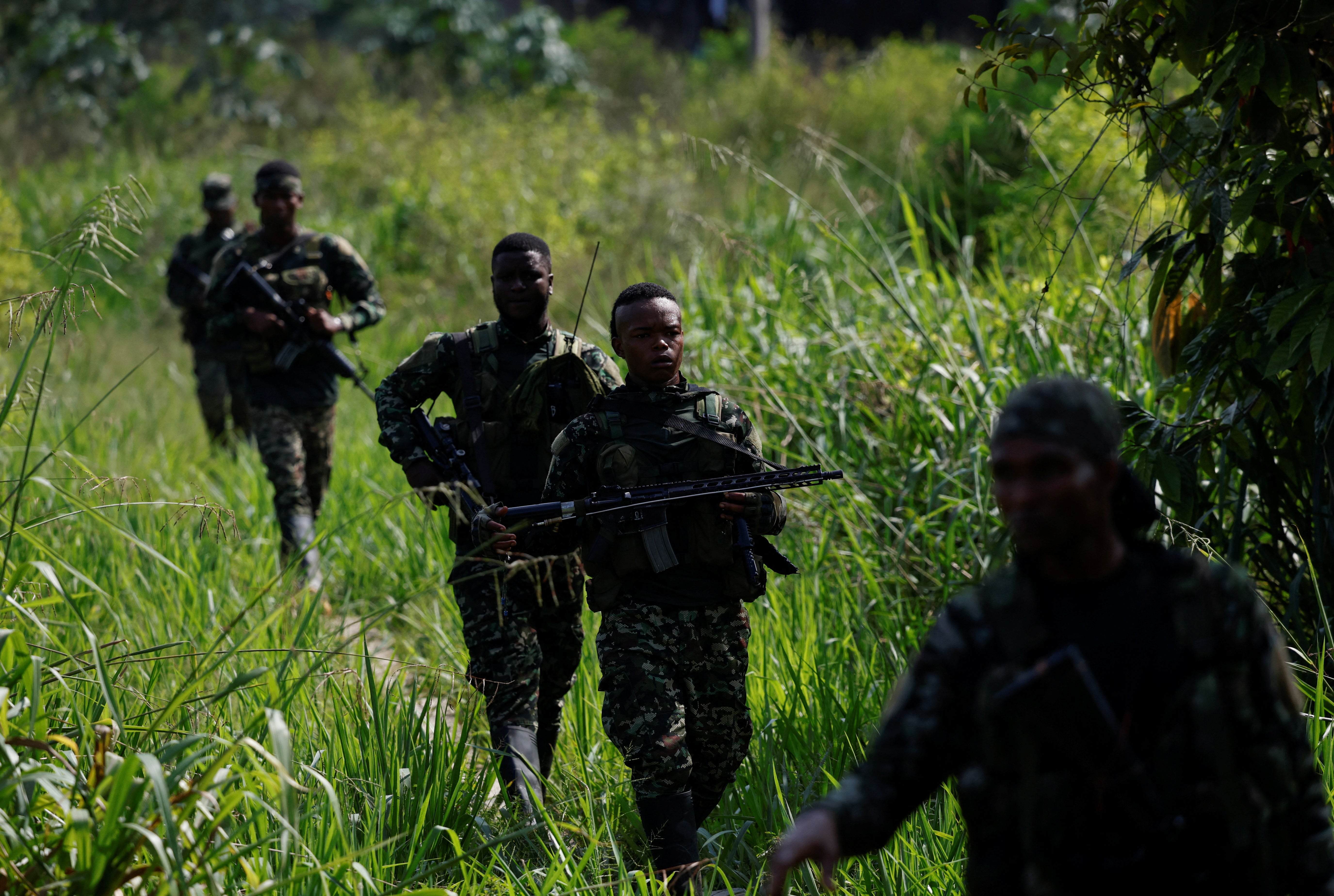 Guerrillas of Colombian rebel group Segunda Marquetalia walk at a base camp, in Colombia’s Pacific jungle, Colombia