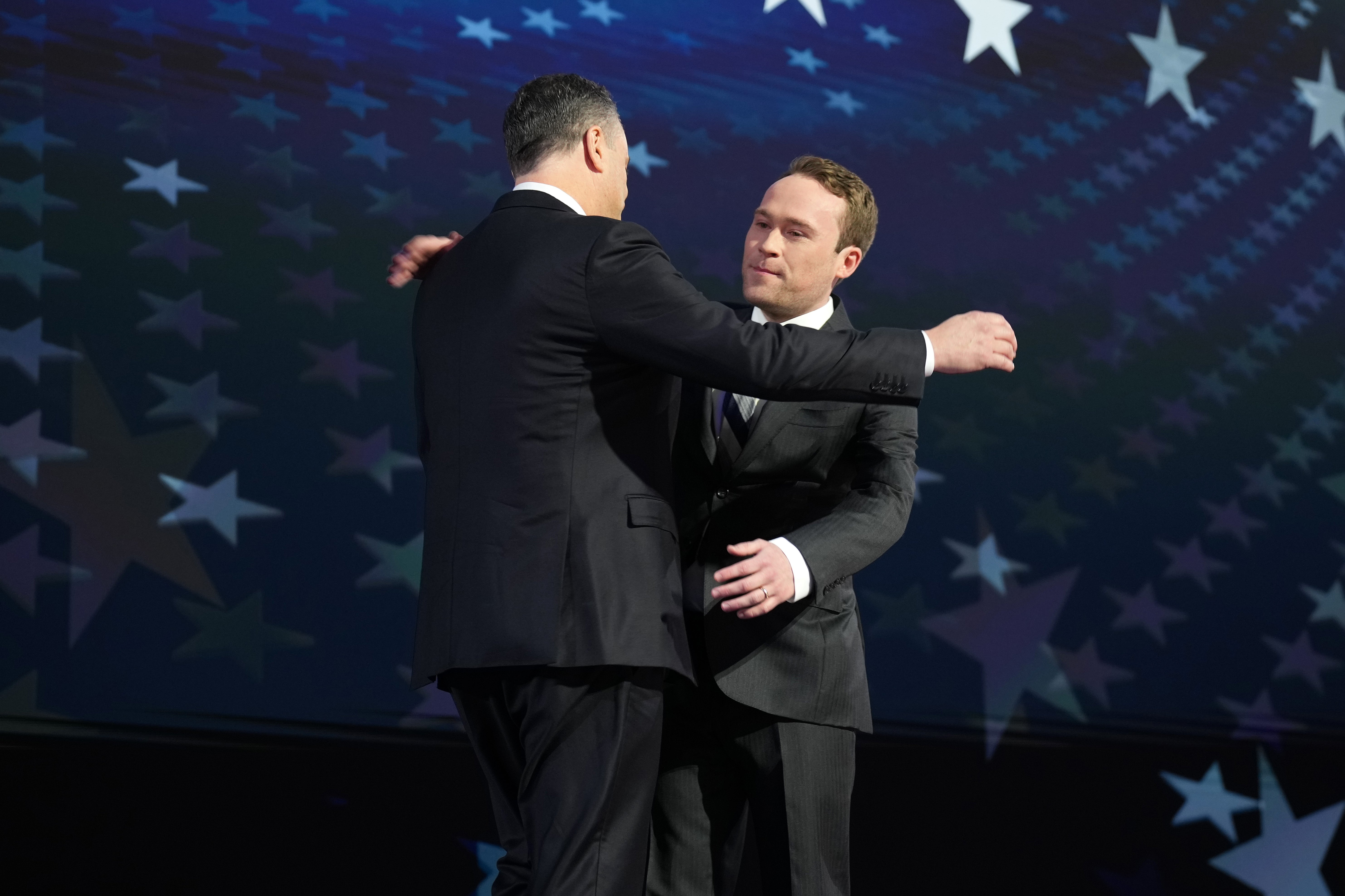 Cole and Doug Emhoff hug on stage at the DNC