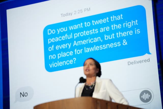 <p>Former Trump White House Press Secretary Stephanie Grisham speaks on stage at the DNC in front of an apparent text message with former first lady Melania Trump</p>