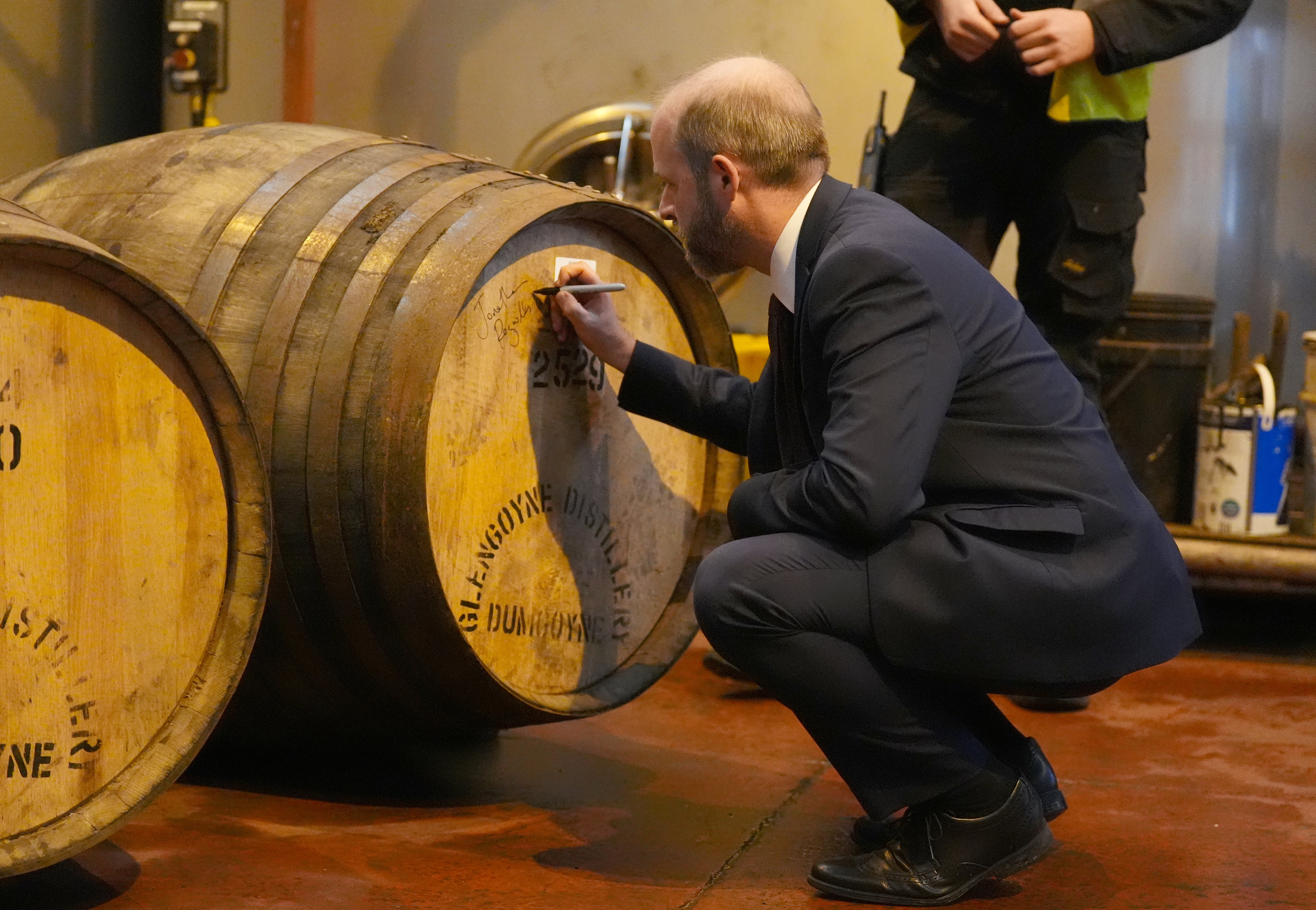 The minister signed a cask after sealing it by hammering in a cork during his distillery visit (Andrew Milligan/PA)