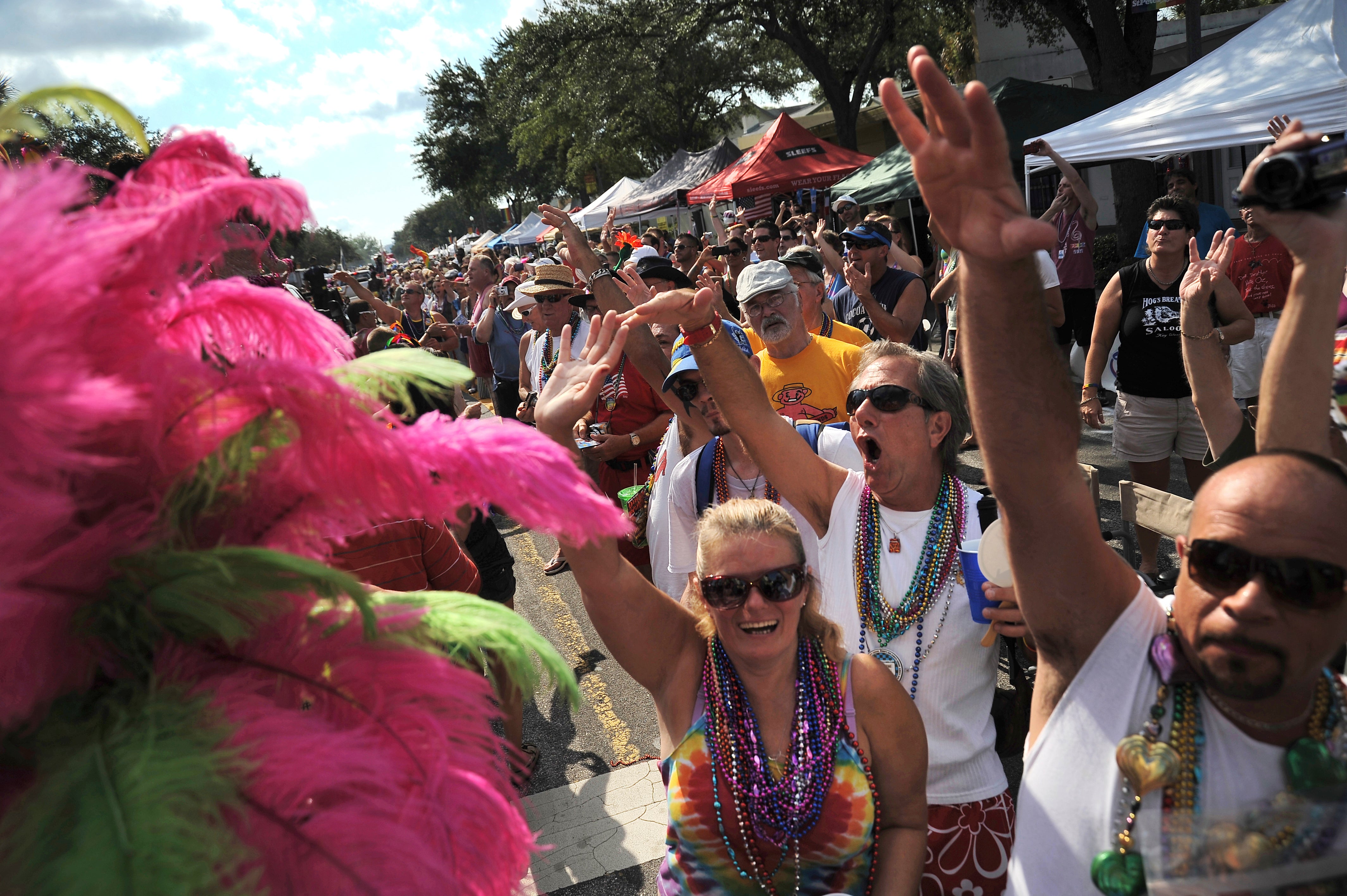 Centenas de pessoas se alinham na Avenida Central e torcem durante o 10º Festival e Passeio Anual da Rua St. Pete Pride em São Petersburgo