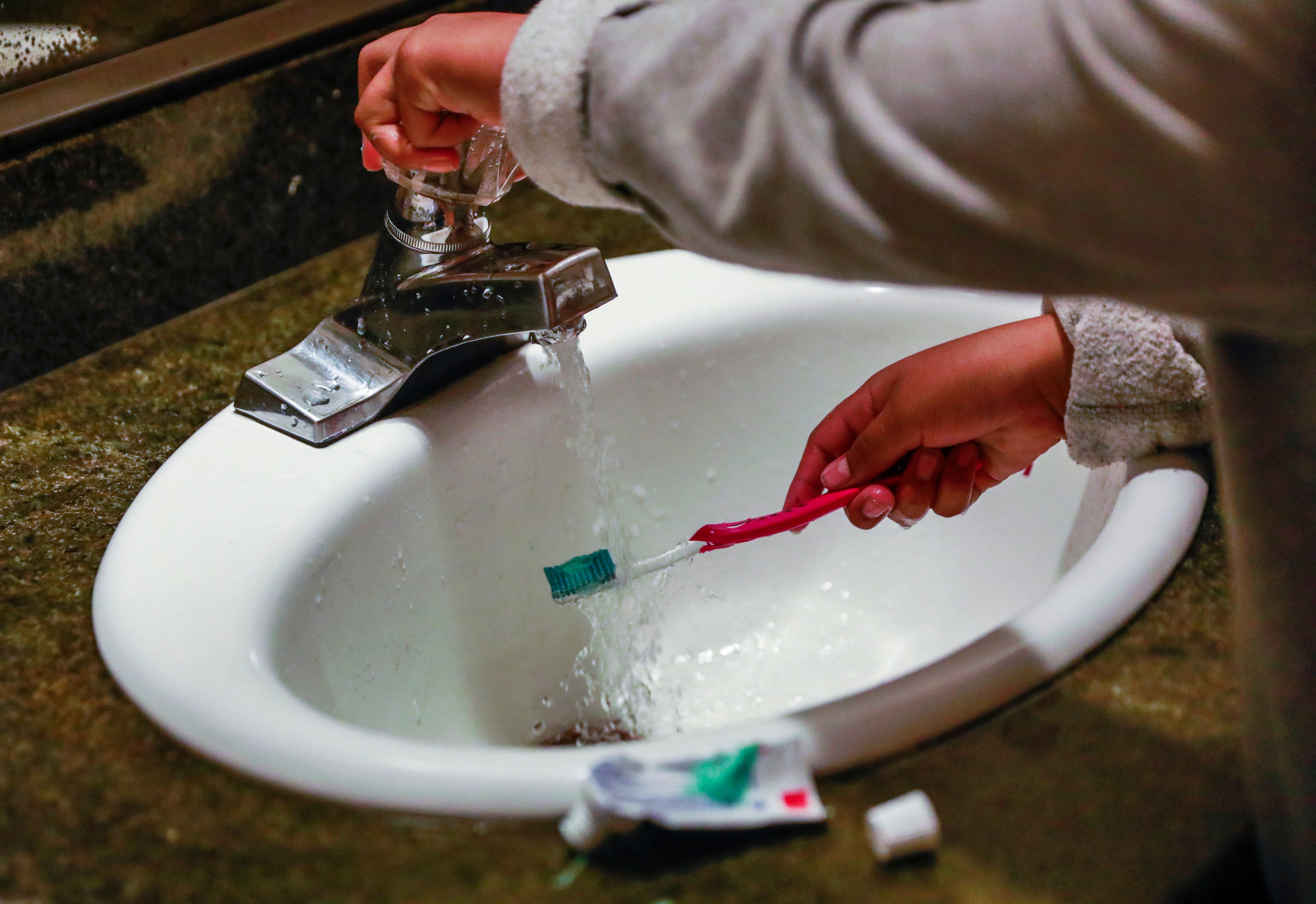 A child rinses a toothbrush in San Francisco