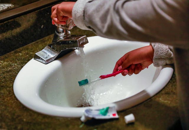 <p>A child rinses a toothbrush in San Francisco</p>