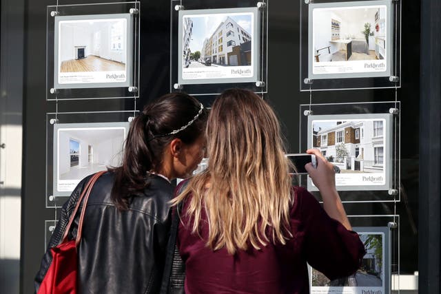 <p>Two women look at property adverts in an estate agent’s window
</p>