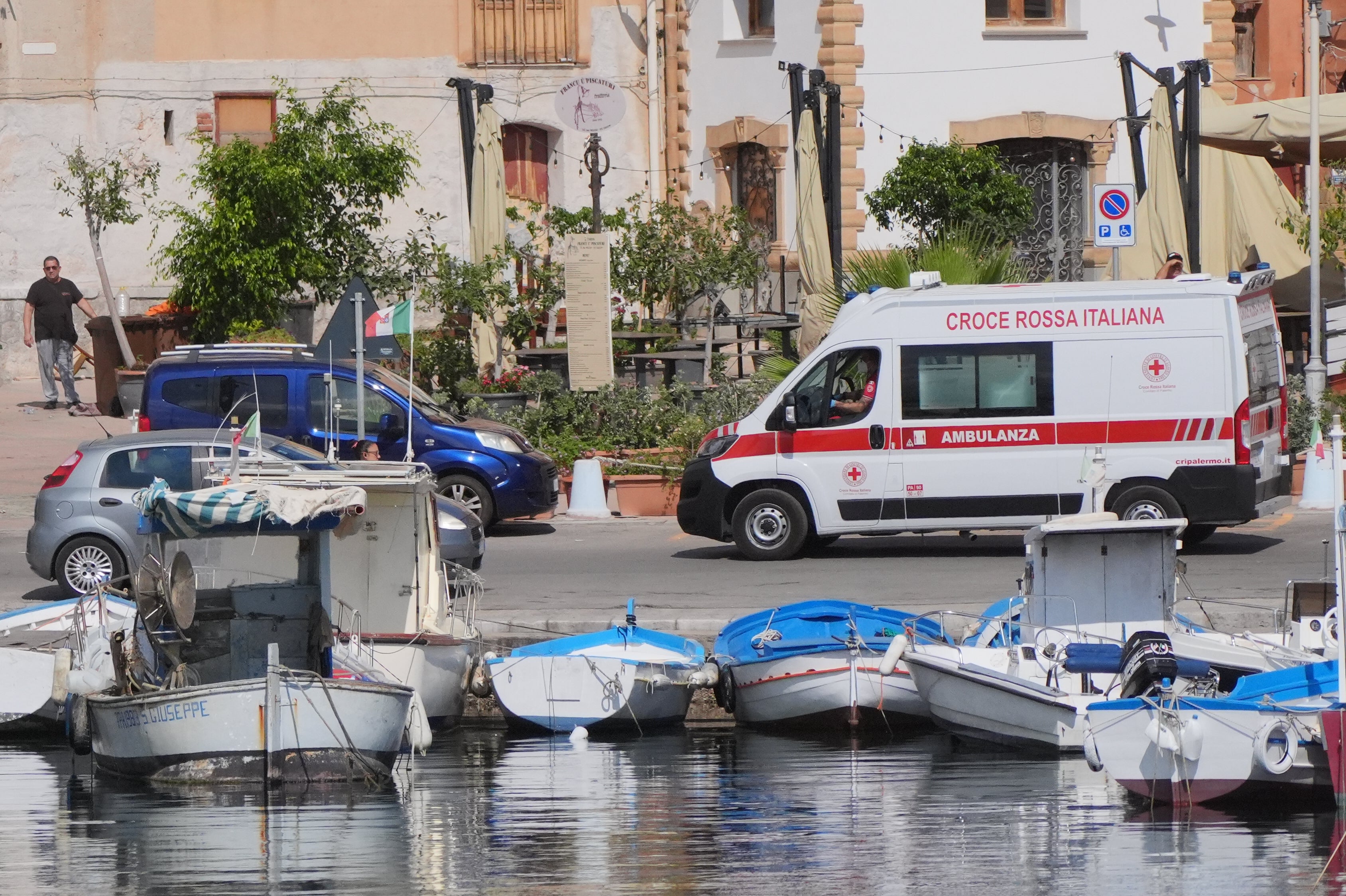 Uma ambulância que transporta o quinto corpo sai do porto de Porticello para o necrotério