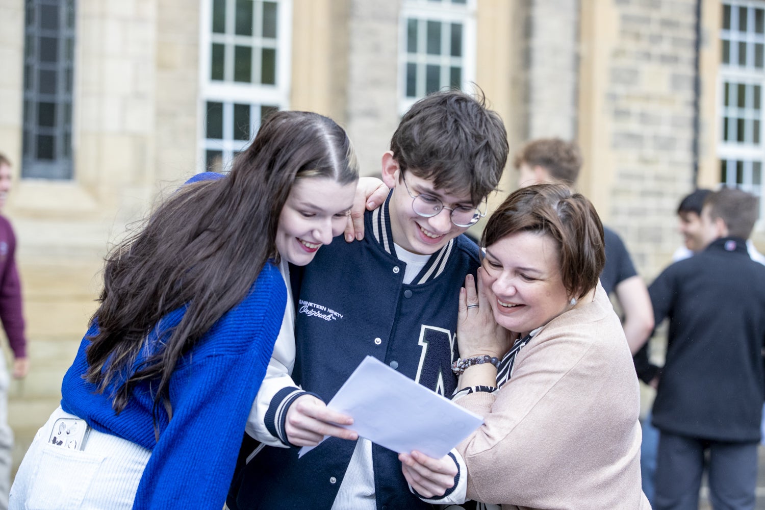 <p>Ukrainian teenager Oles Kuzomko is hugged by his sister Yaryna and mother Mila after achieving ‘excellent’ GCSE results at Bradford Grammar School (Stephen Garnett Photography/PA)</p>