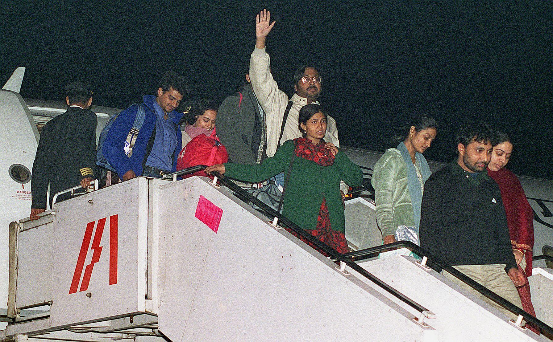 A group of hostages disembark from a plane at New Delhi International Airport on December 31, 1999