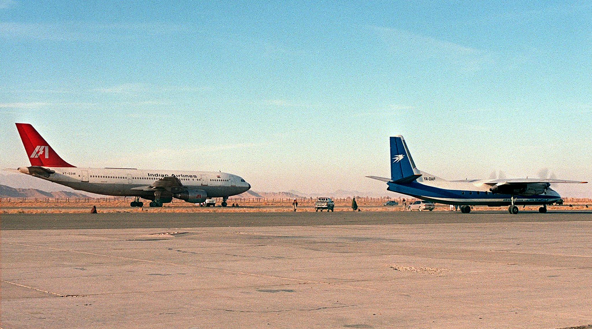 The hijacked Indian Airlines Airbus A300 (left) stands on the runway of Kandahar Airport in southern Afghanistan on December 26, 1999.