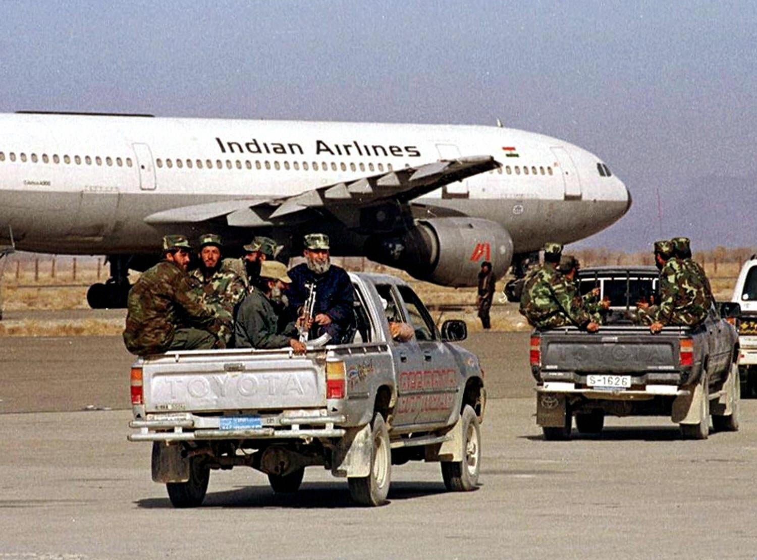 Milícia Taliban afegã dirige-se a um Airbus AC-814 da Indian Airlines sequestrado no aeroporto de Kandahar em 27 de dezembro de 1999