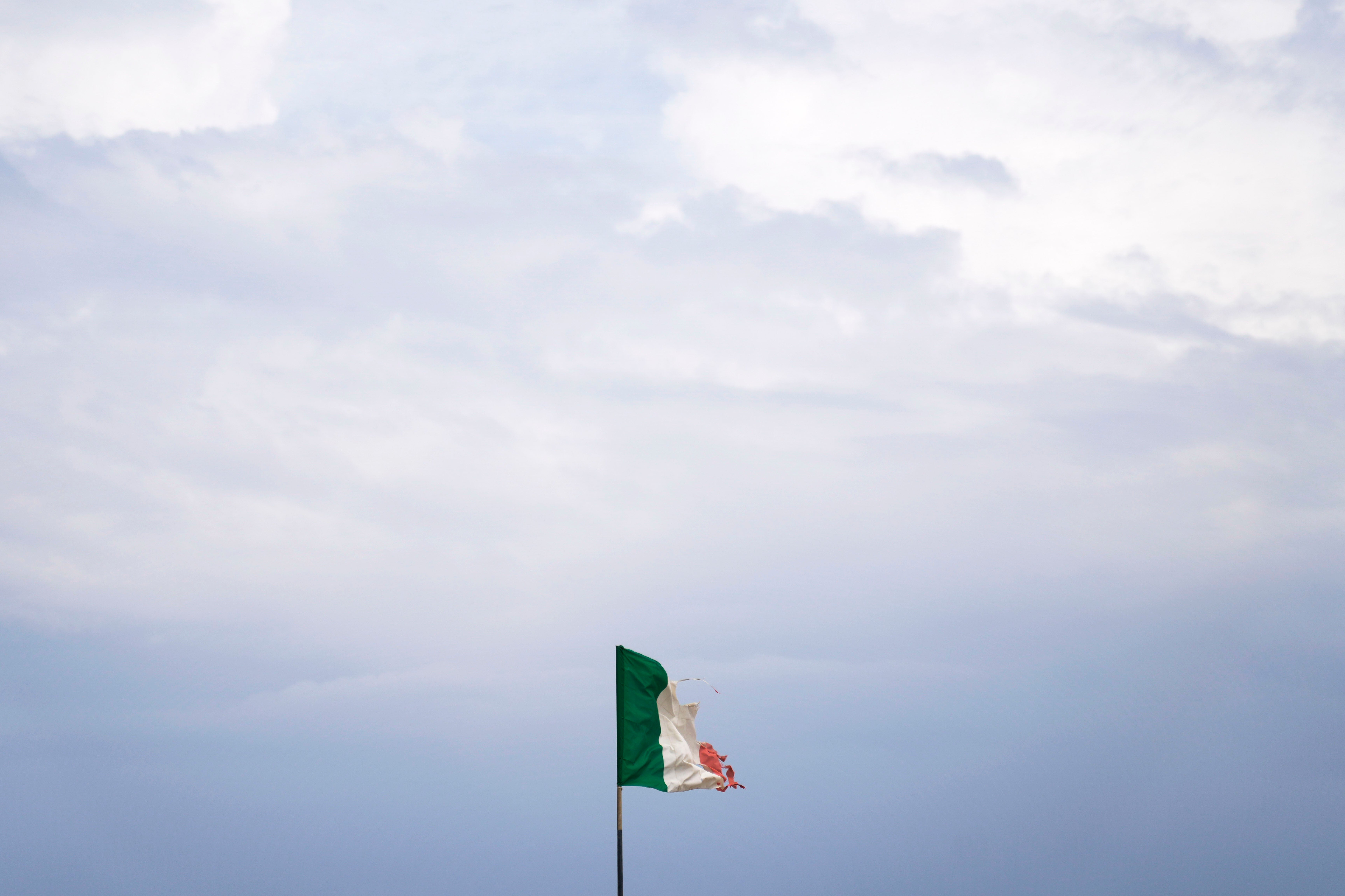 Uma desgastada bandeira italiana tremula ao vento em um estabelecimento de praia em Ostia, perto de Roma