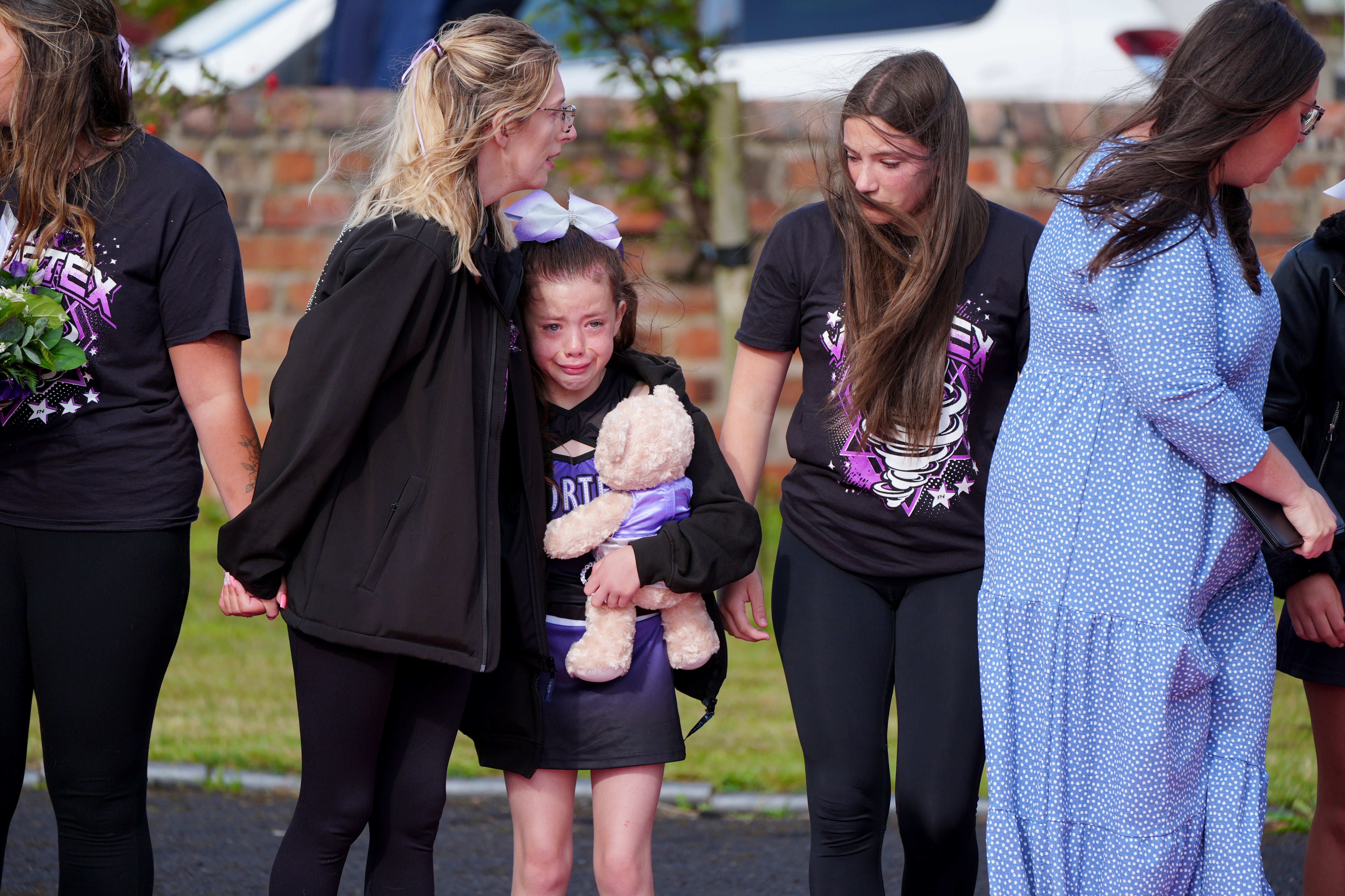 Devastated friends, family, and members of the local community watched the procession pass by