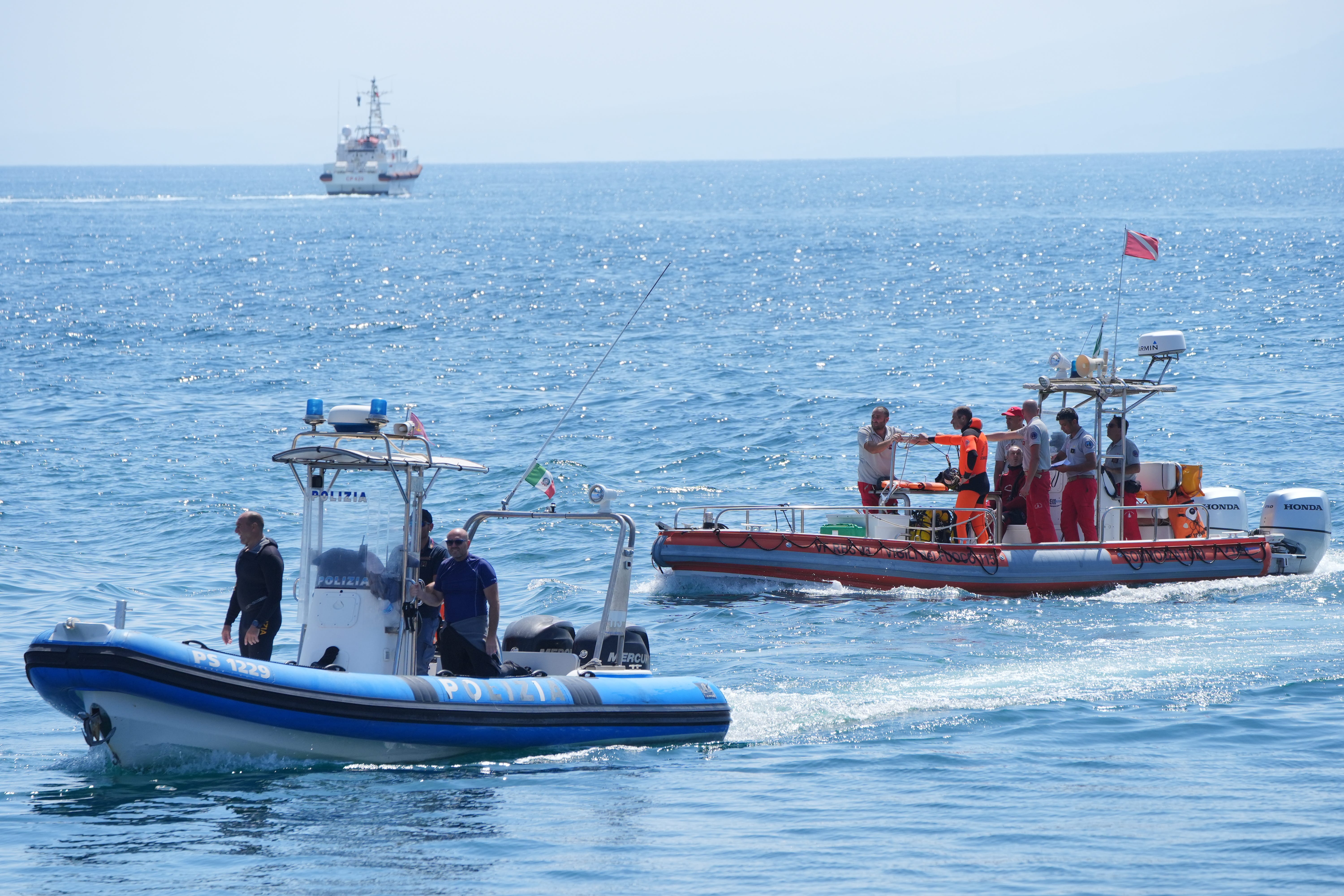 An Italian fire service dive team returns to port on the fifth day of the search