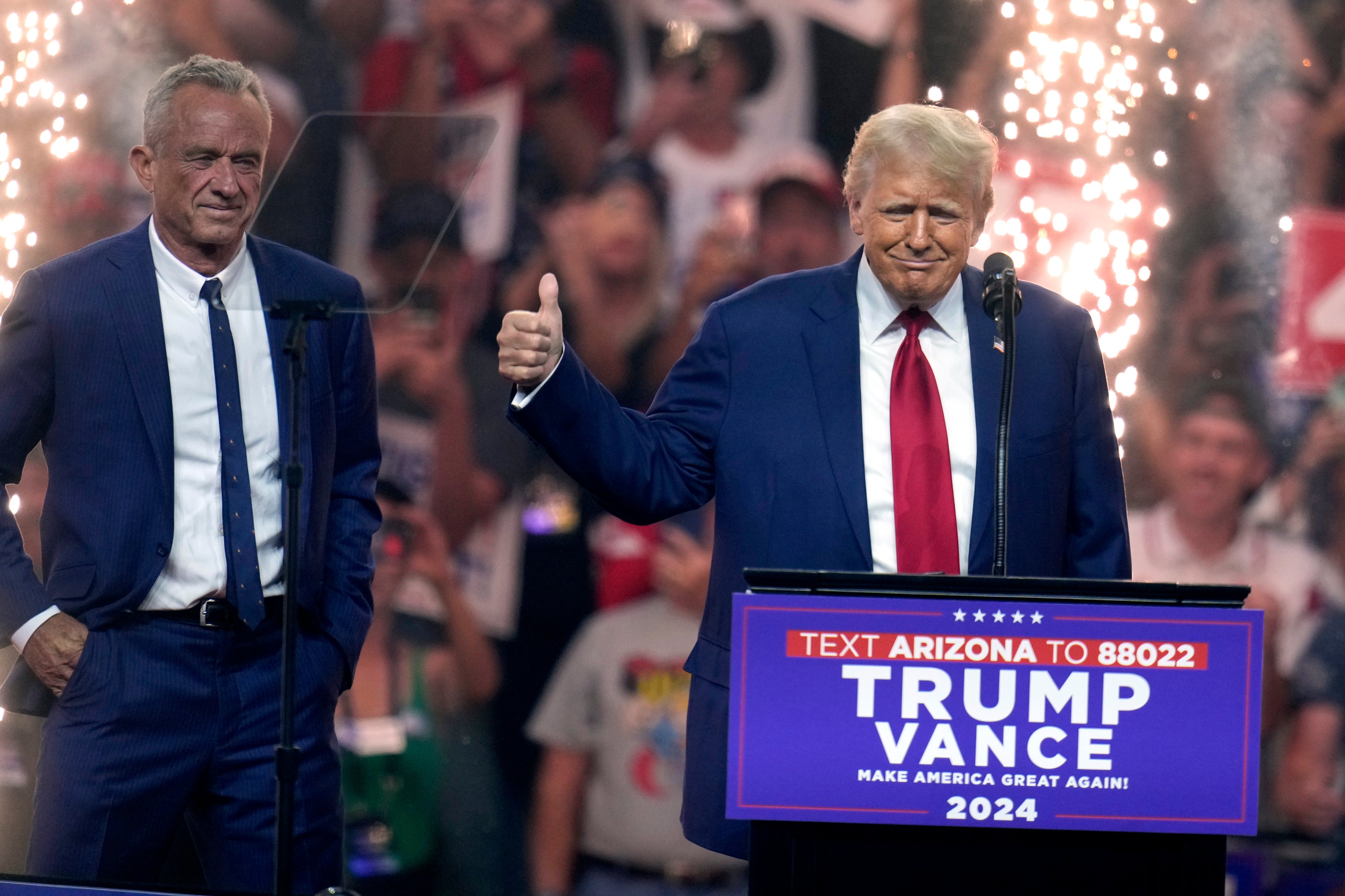 Independent presidential candidate Robert F. Kennedy Jr., left, looks on as Republican presidential nominee former President Donald Trump speaks at a campaign rally Friday, Aug. 23, 2024, in Glendale, Ariz. (AP Photo/Ross D. Franklin)